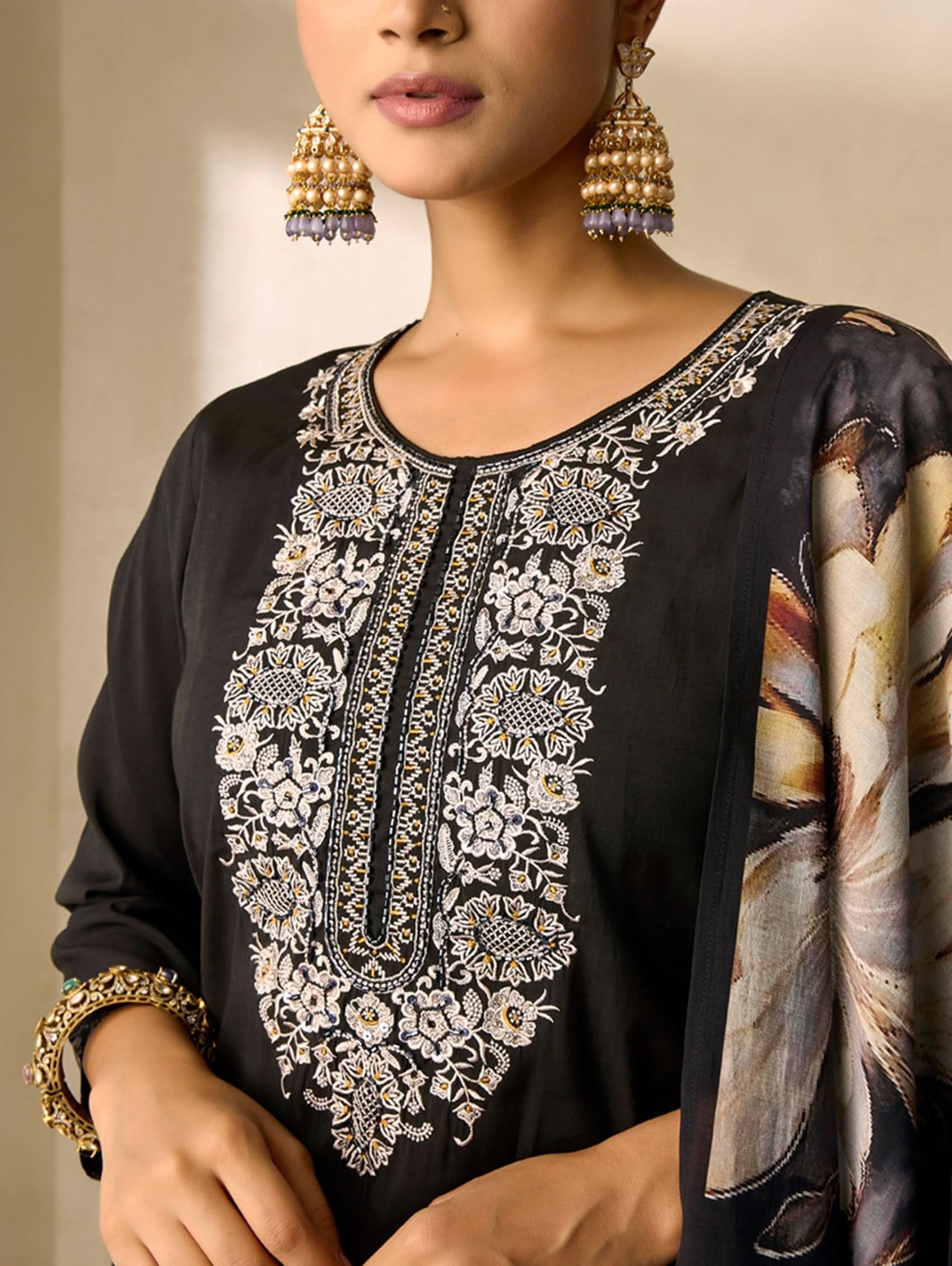 Black embroidered top with gold detailing worn by a model
