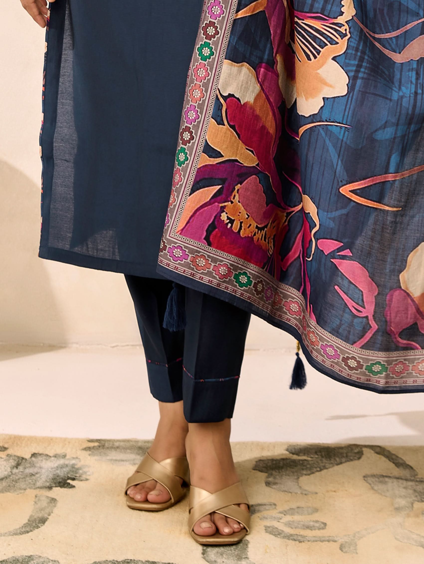 Person wearing a navy blue outfit with a colorful floral patterned scarf.