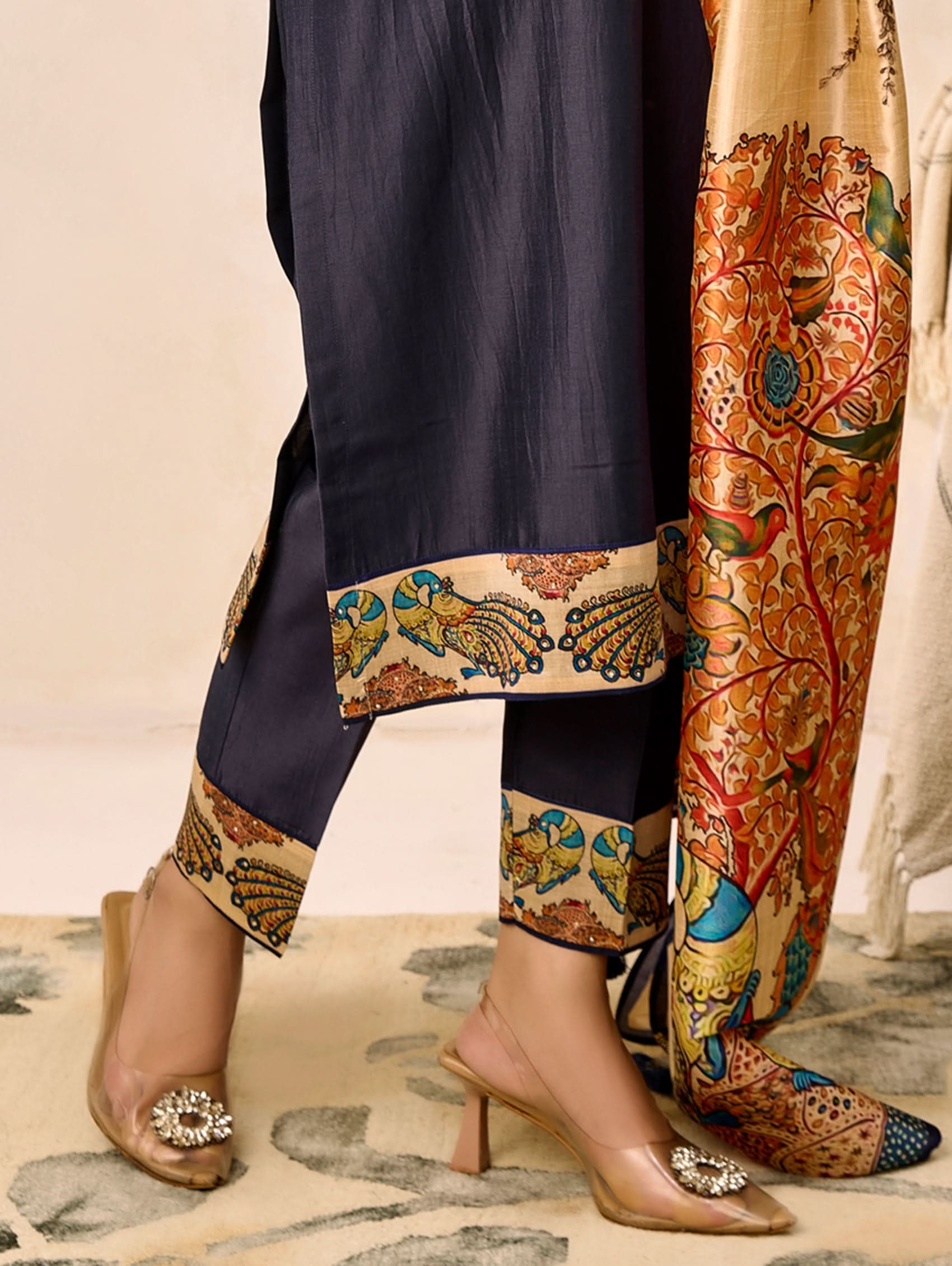 Navy blue outfit with colorful patterned pants and a matching shawl on a neutral background