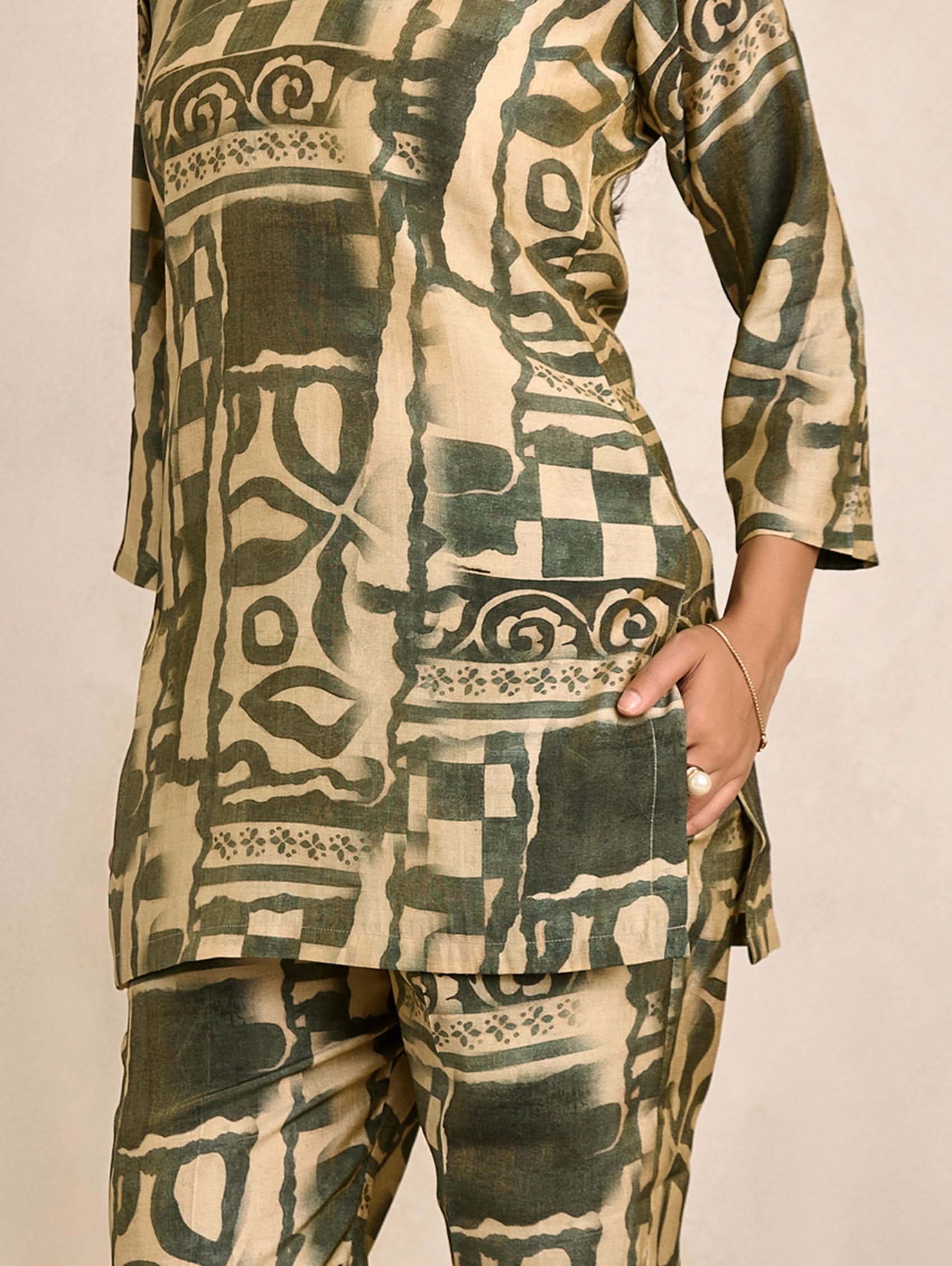 Traditional patterned outfit with long sleeves and pants on a beige background