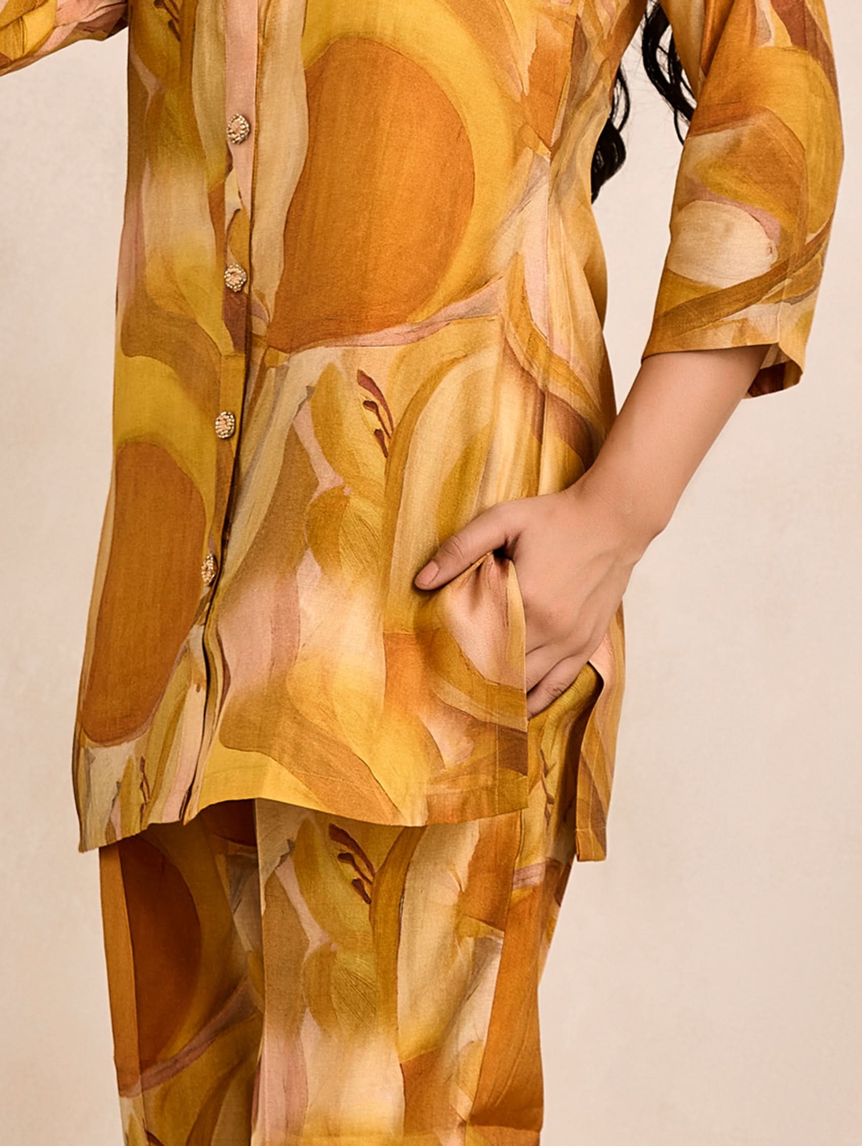 Person wearing a patterned outfit with a neutral background