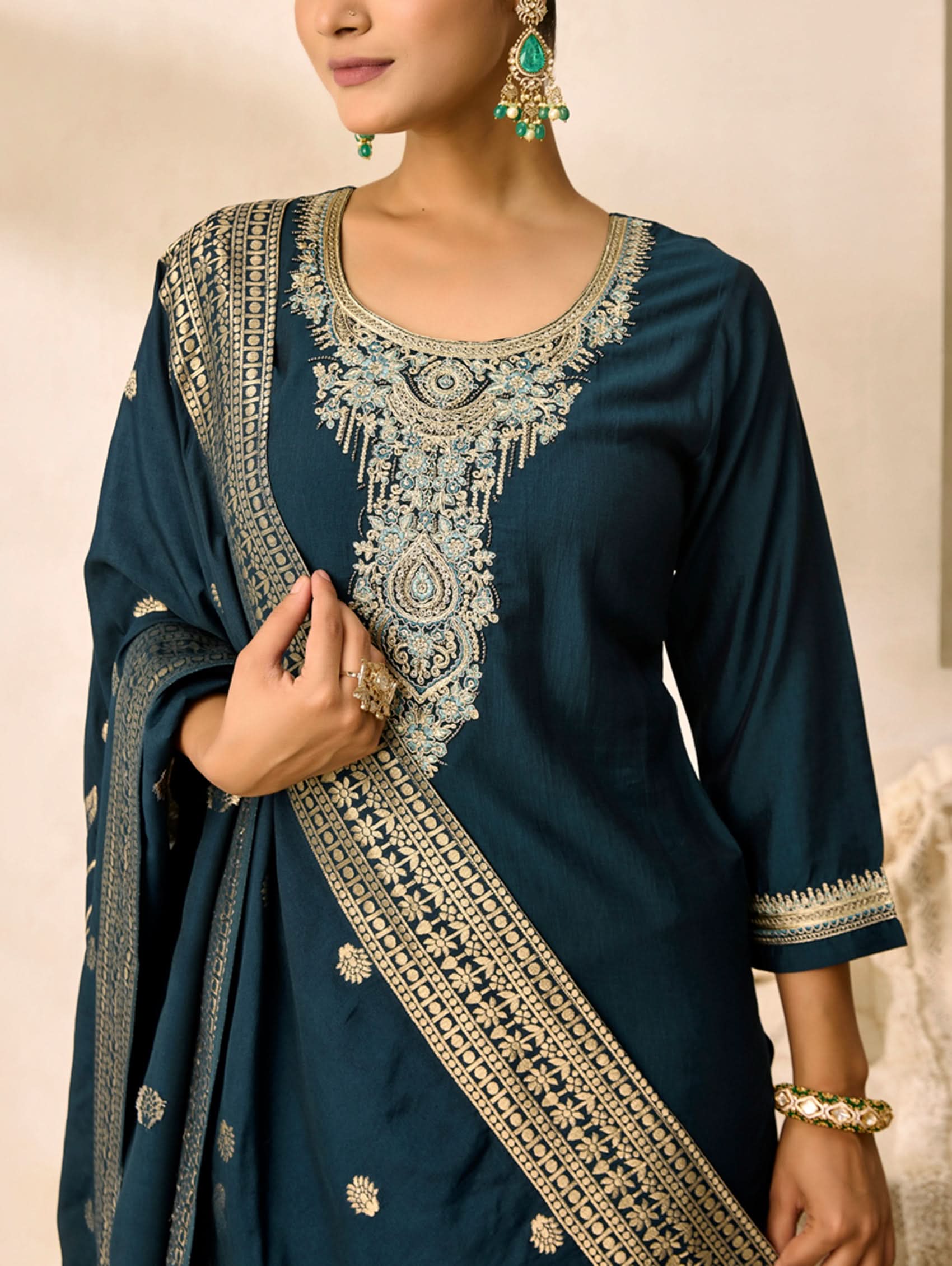 Navy blue traditional outfit with intricate white embroidery on a neutral background