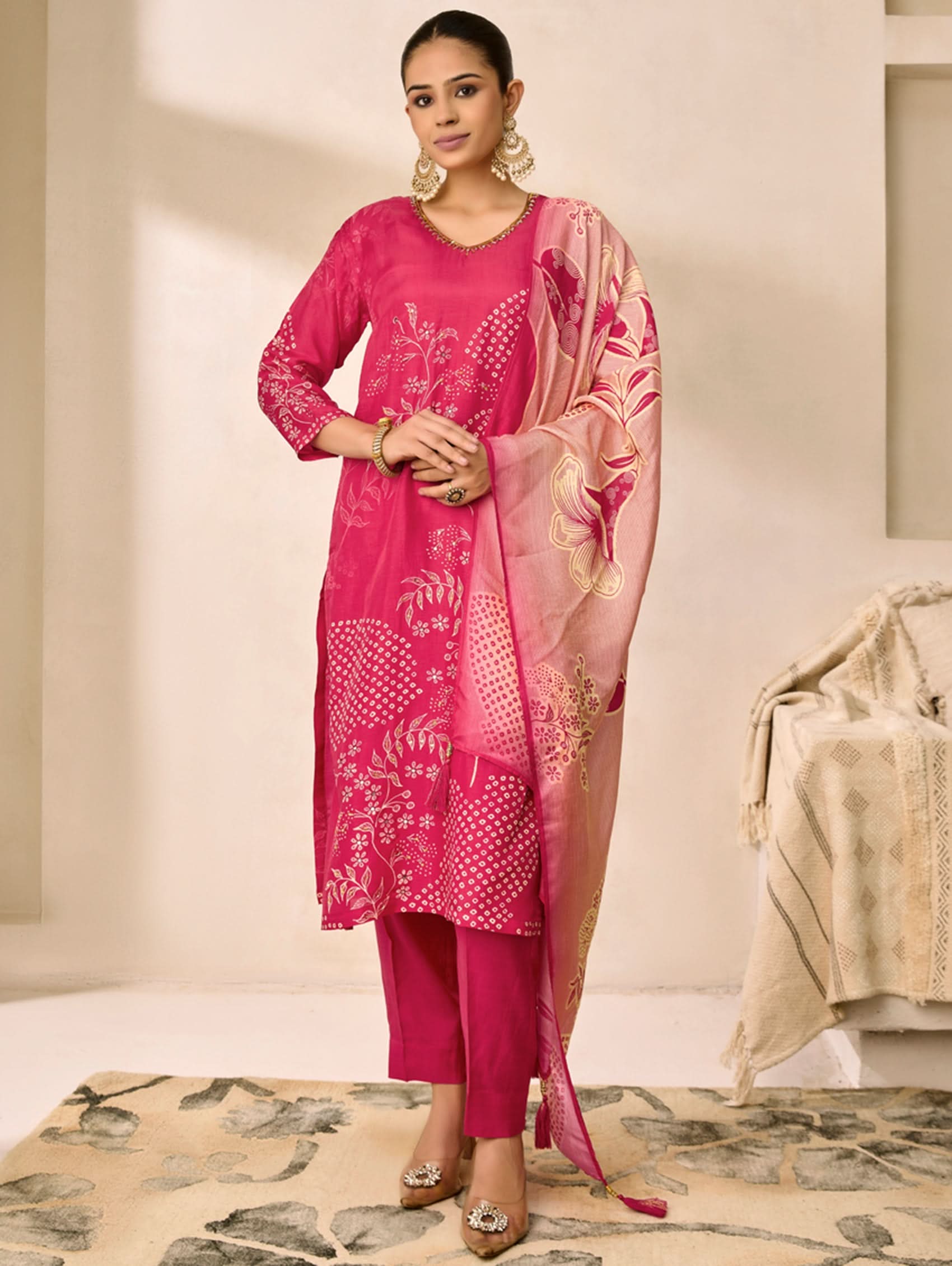 Woman wearing a pink traditional outfit with a matching dupatta in a neutral setting
