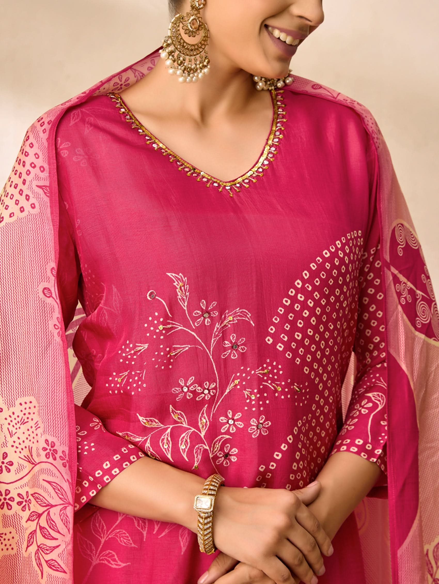 Woman wearing a pink traditional outfit with floral patterns on a beige background