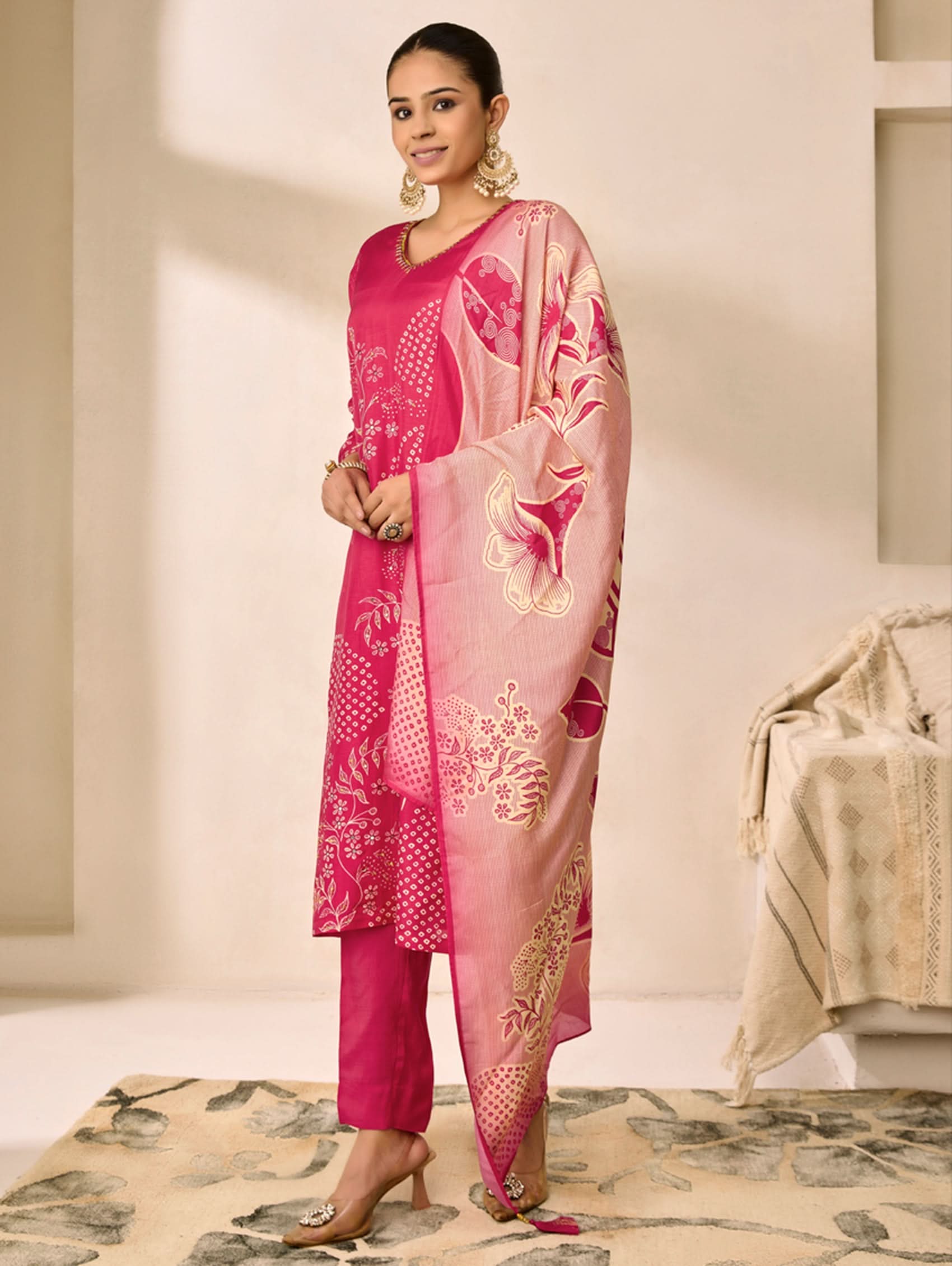 Woman wearing a pink traditional outfit with a matching dupatta in a well-lit room.