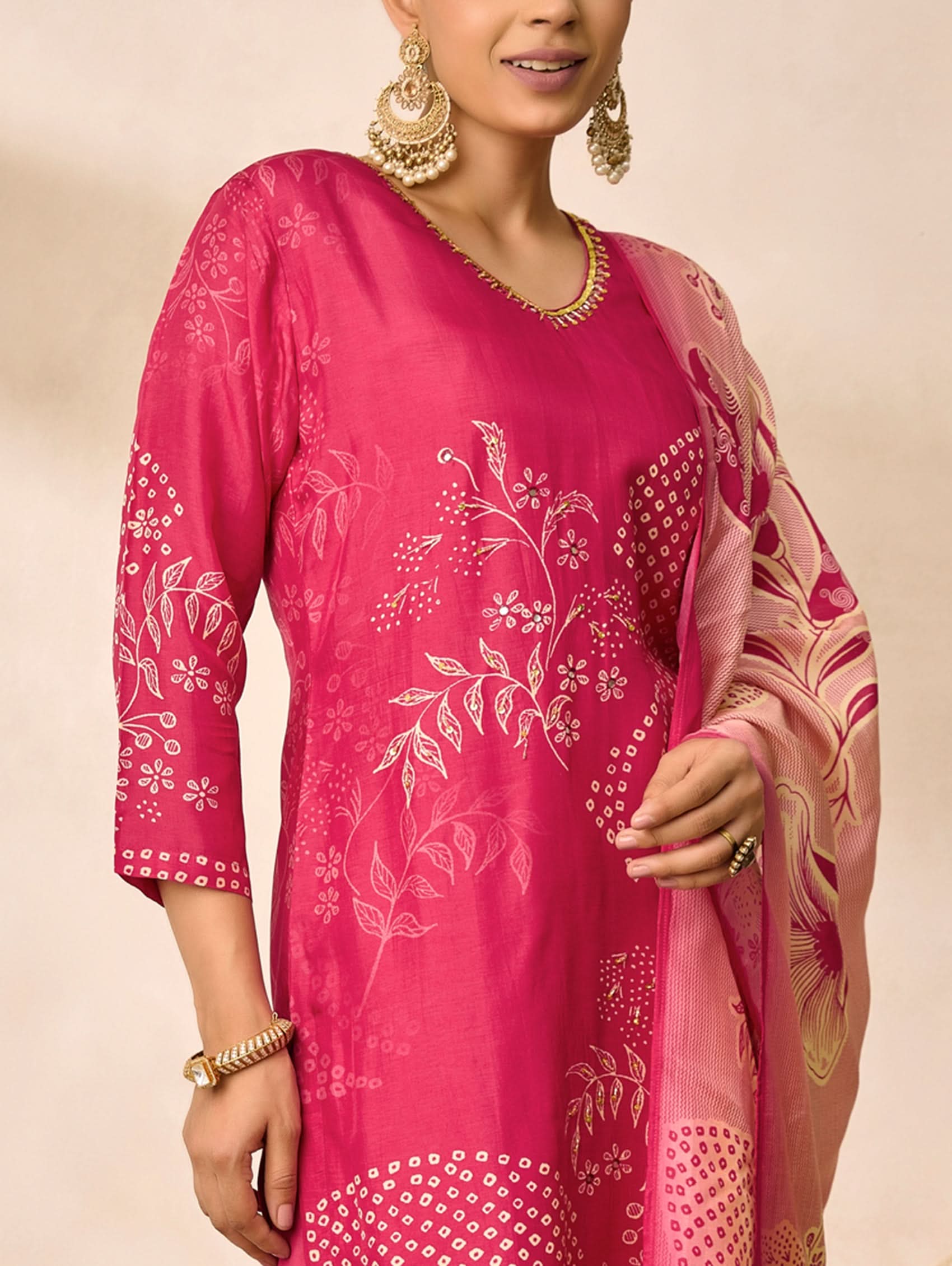 Woman wearing a pink traditional outfit with floral patterns on a beige background