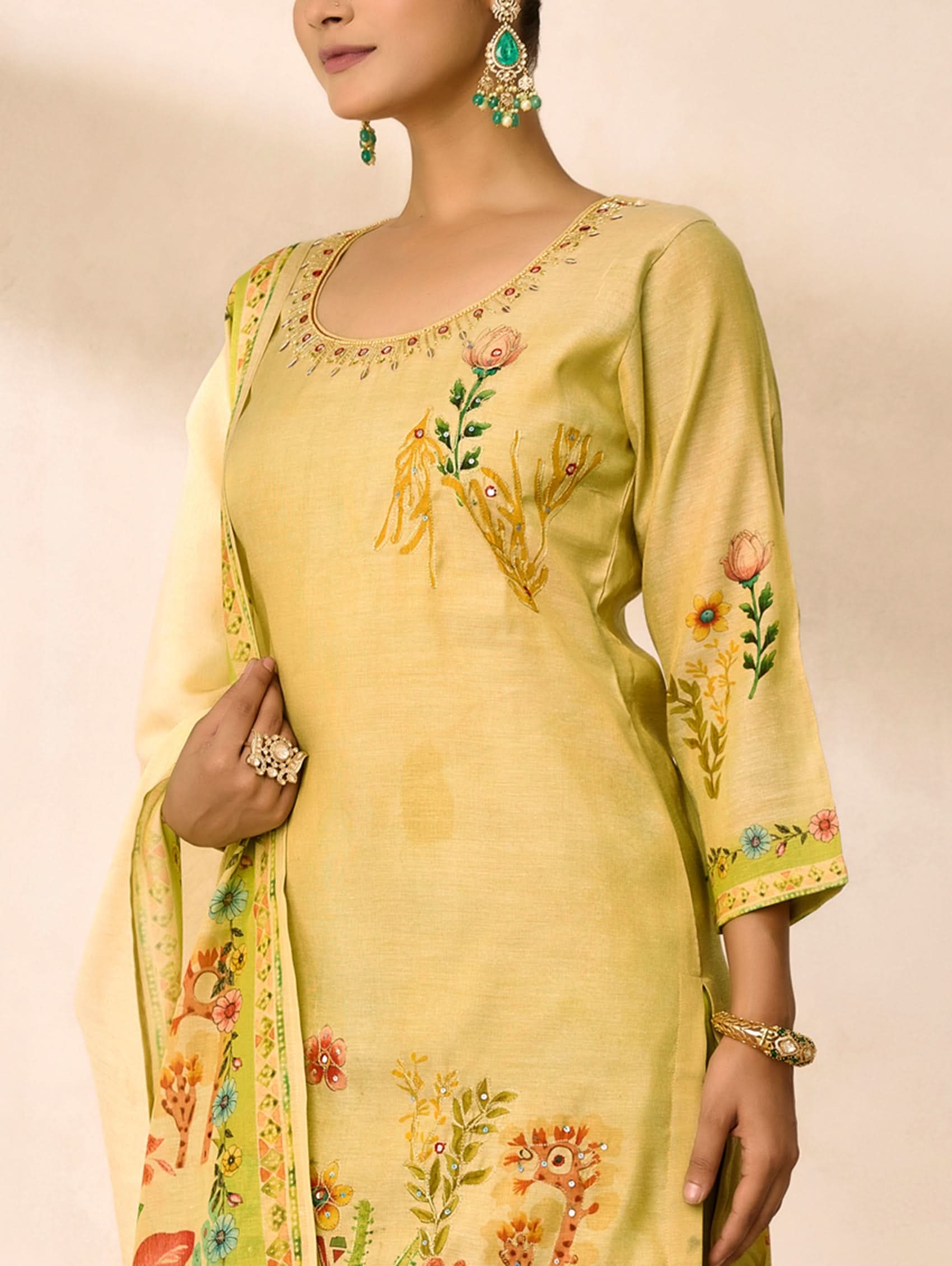 Yellow embroidered traditional outfit with a matching dupatta on a neutral background