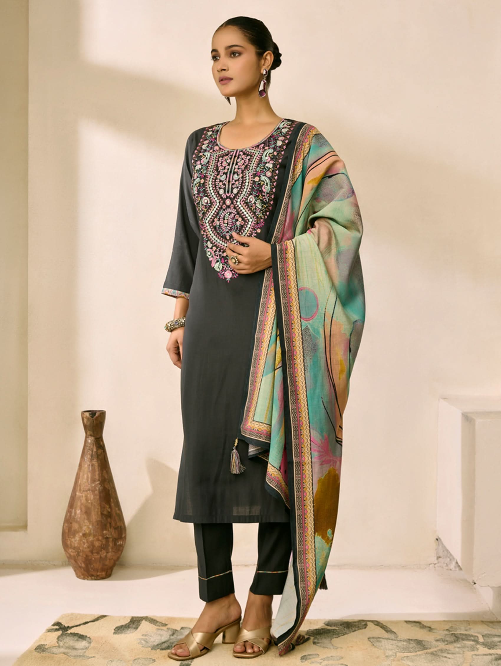 Woman wearing a traditional outfit with a colorful scarf in a well-lit room.