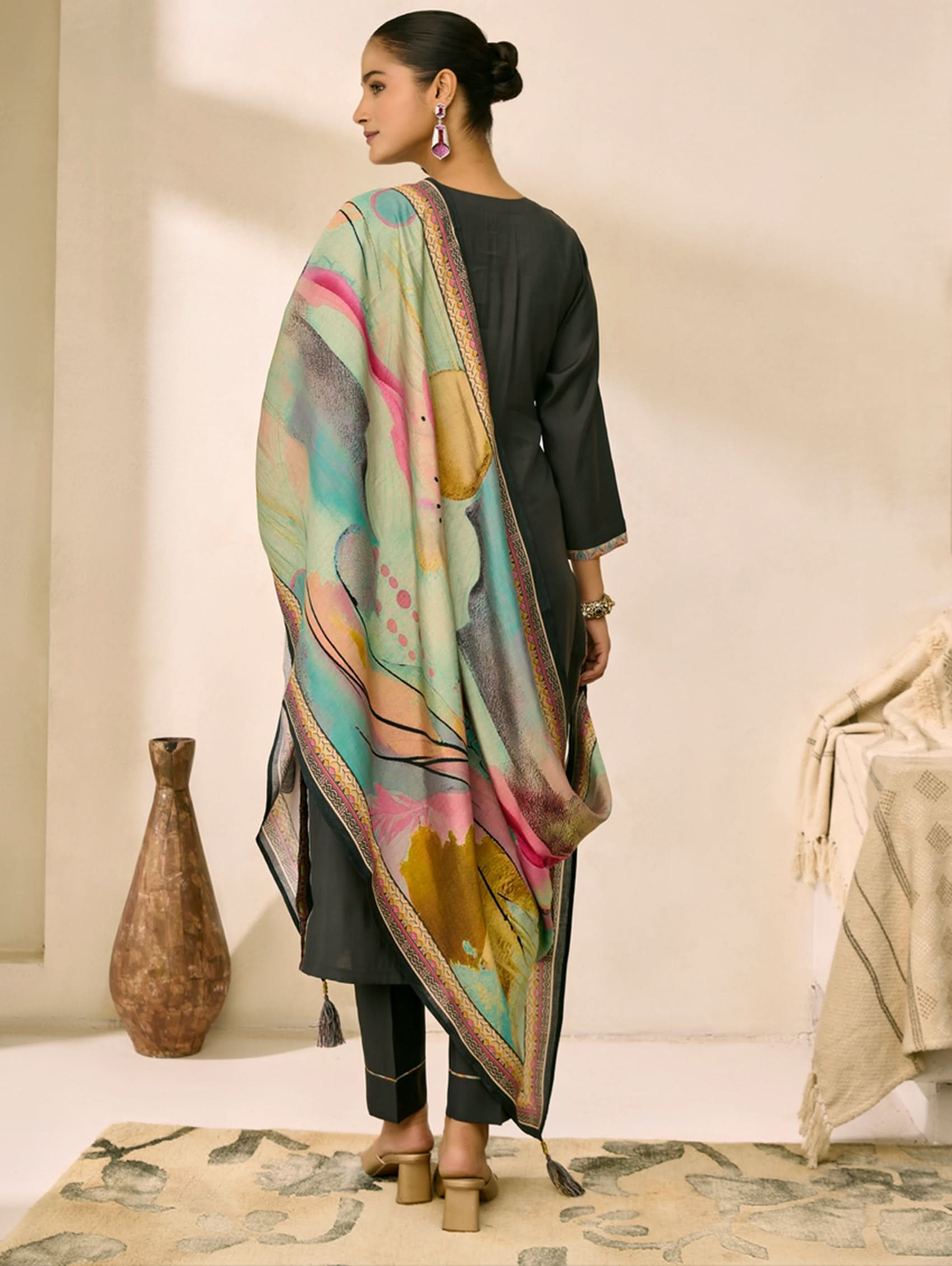 Woman wearing a colorful scarf with a neutral background