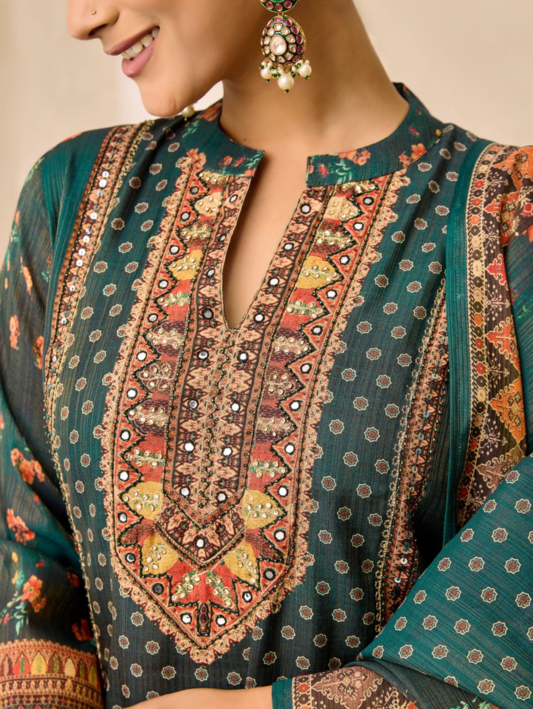 Close-up of a person wearing a traditional embroidered garment with intricate patterns.