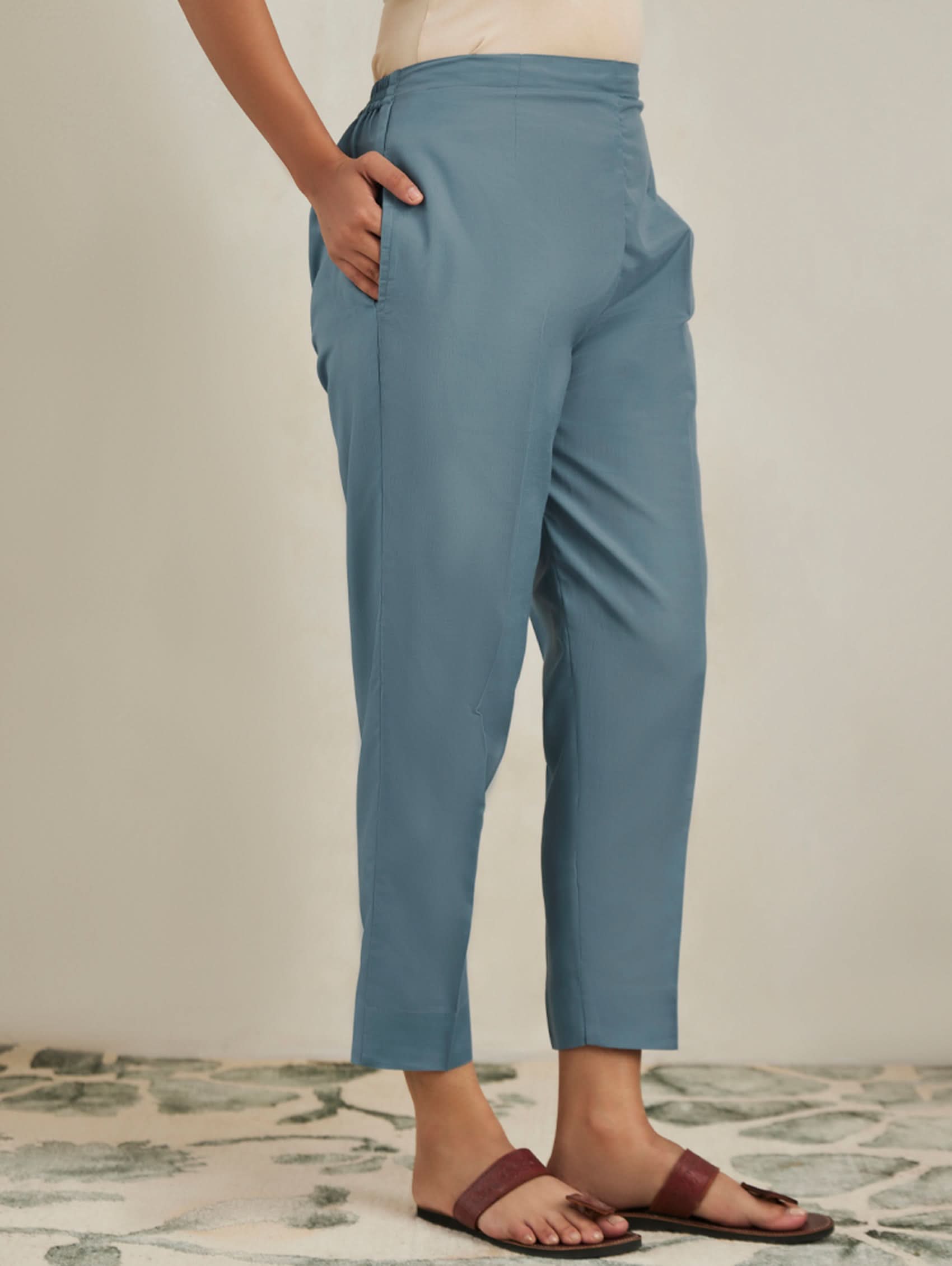 Person wearing blue pants on a neutral background