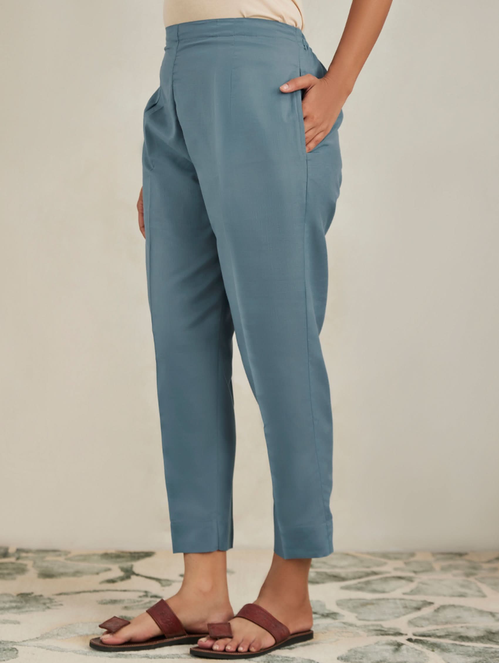 Person wearing blue pants with a neutral background