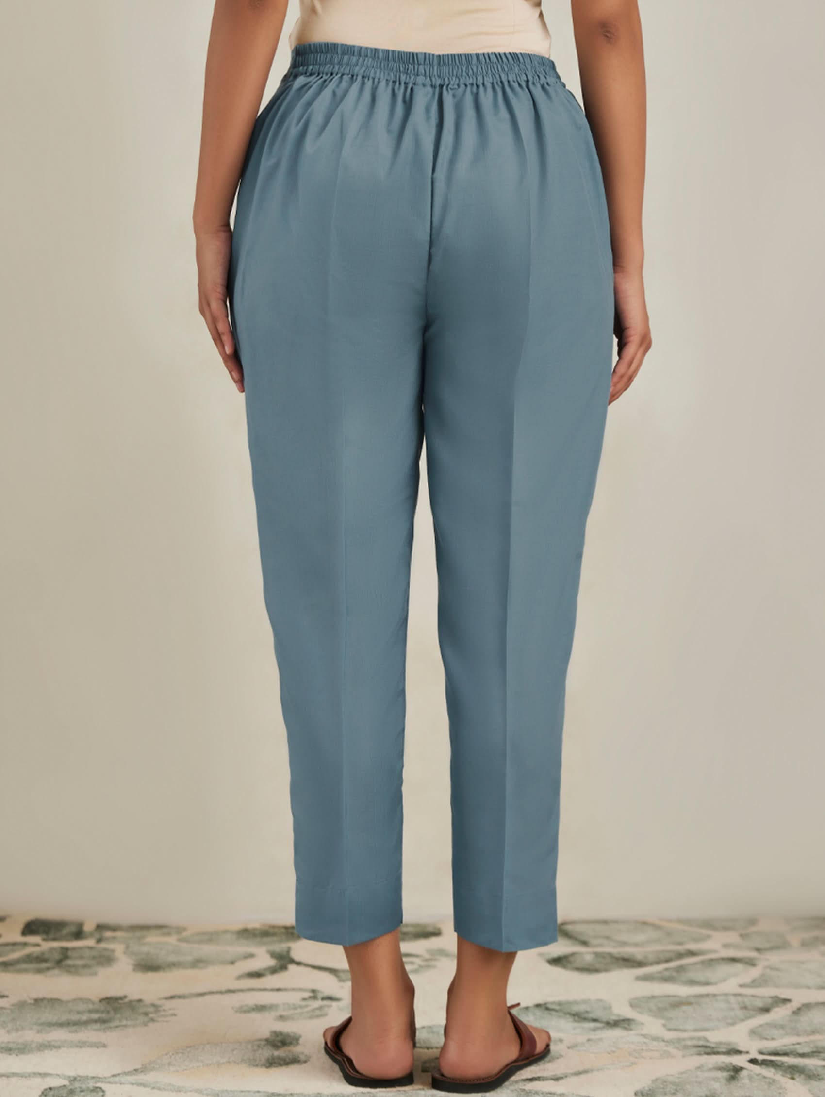 Person wearing blue pants on a neutral background