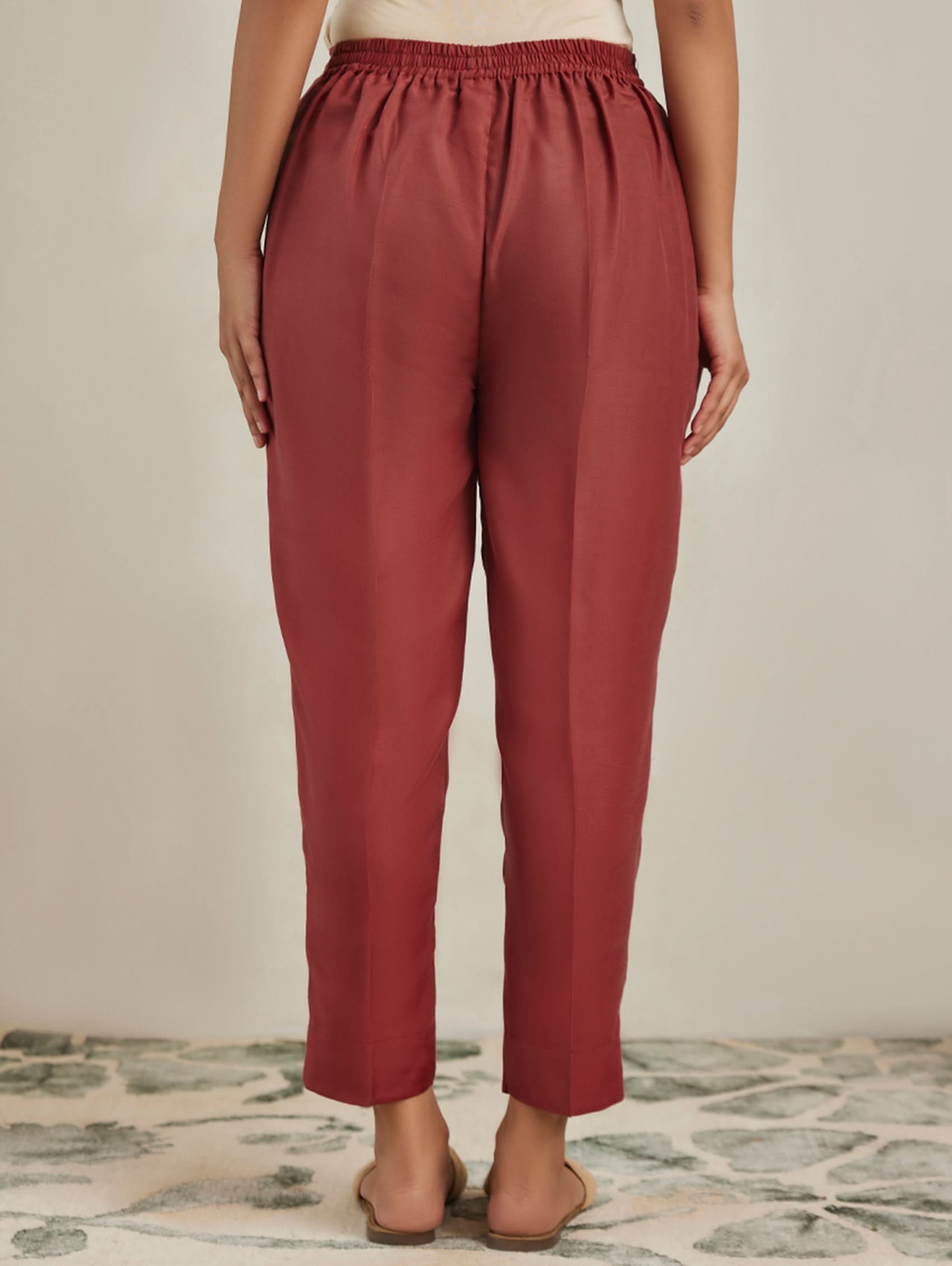 Person wearing red pants on a neutral background