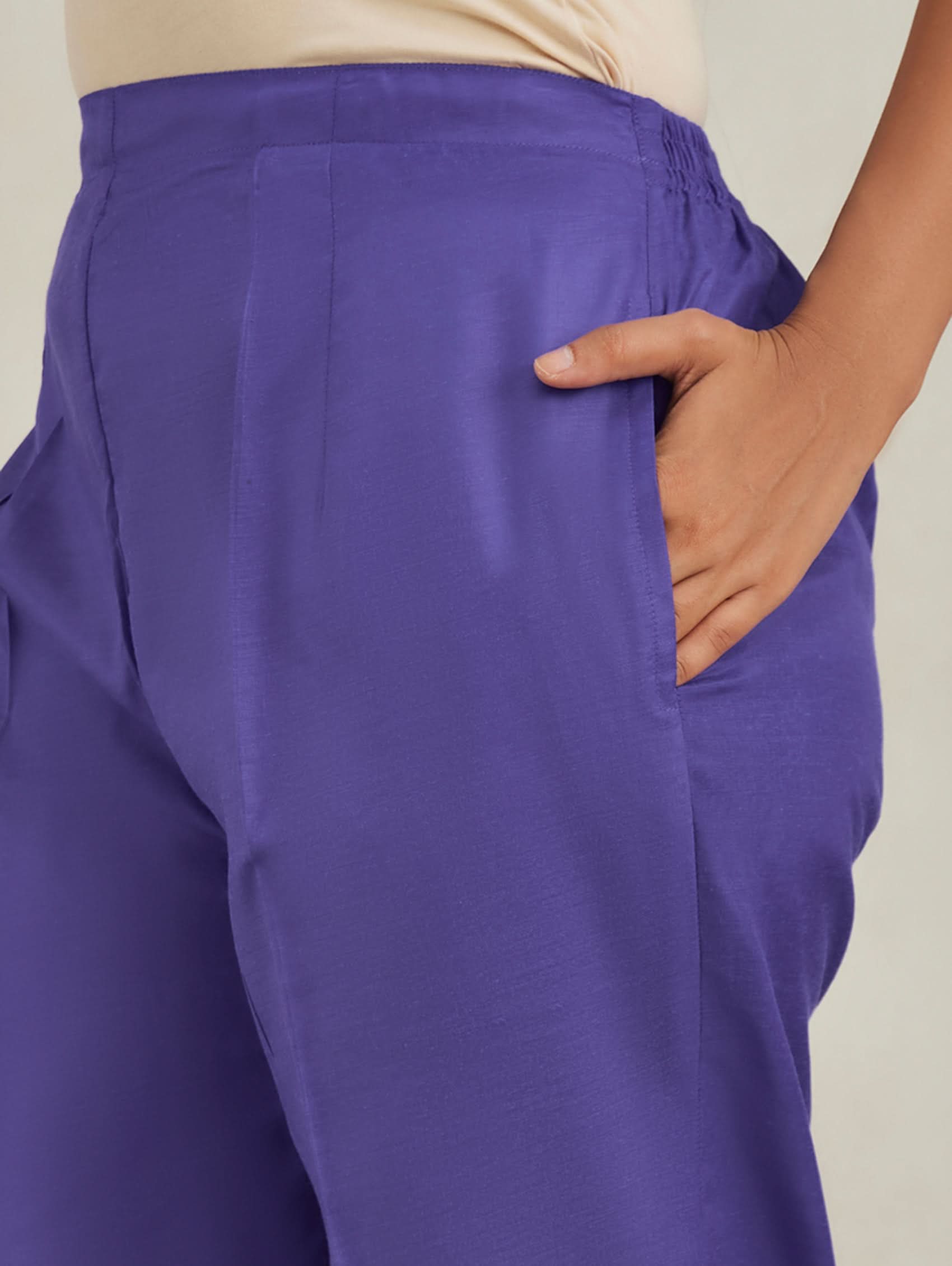 Purple pants worn by a person with a neutral background