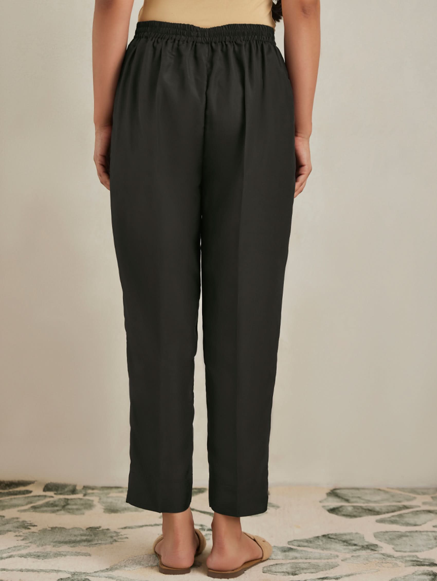 Black pants worn by a person on a neutral background