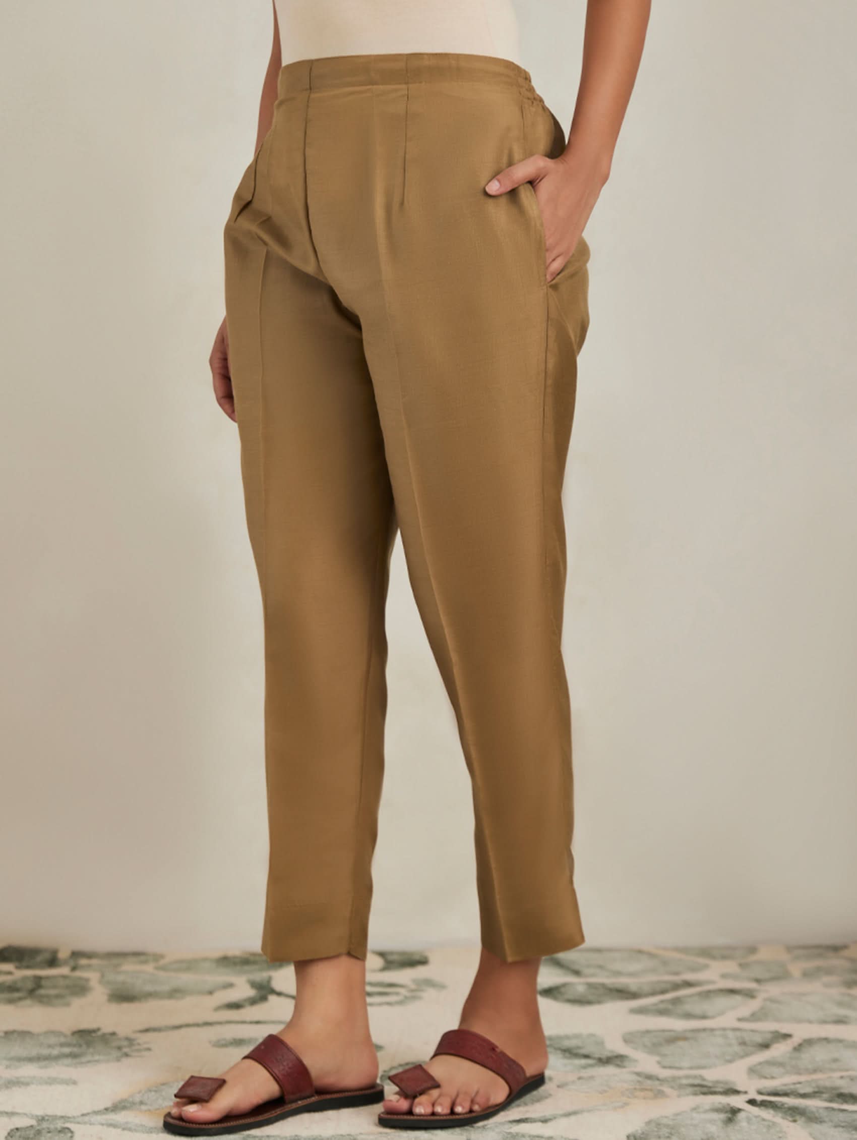 Person wearing tan pants with a neutral background