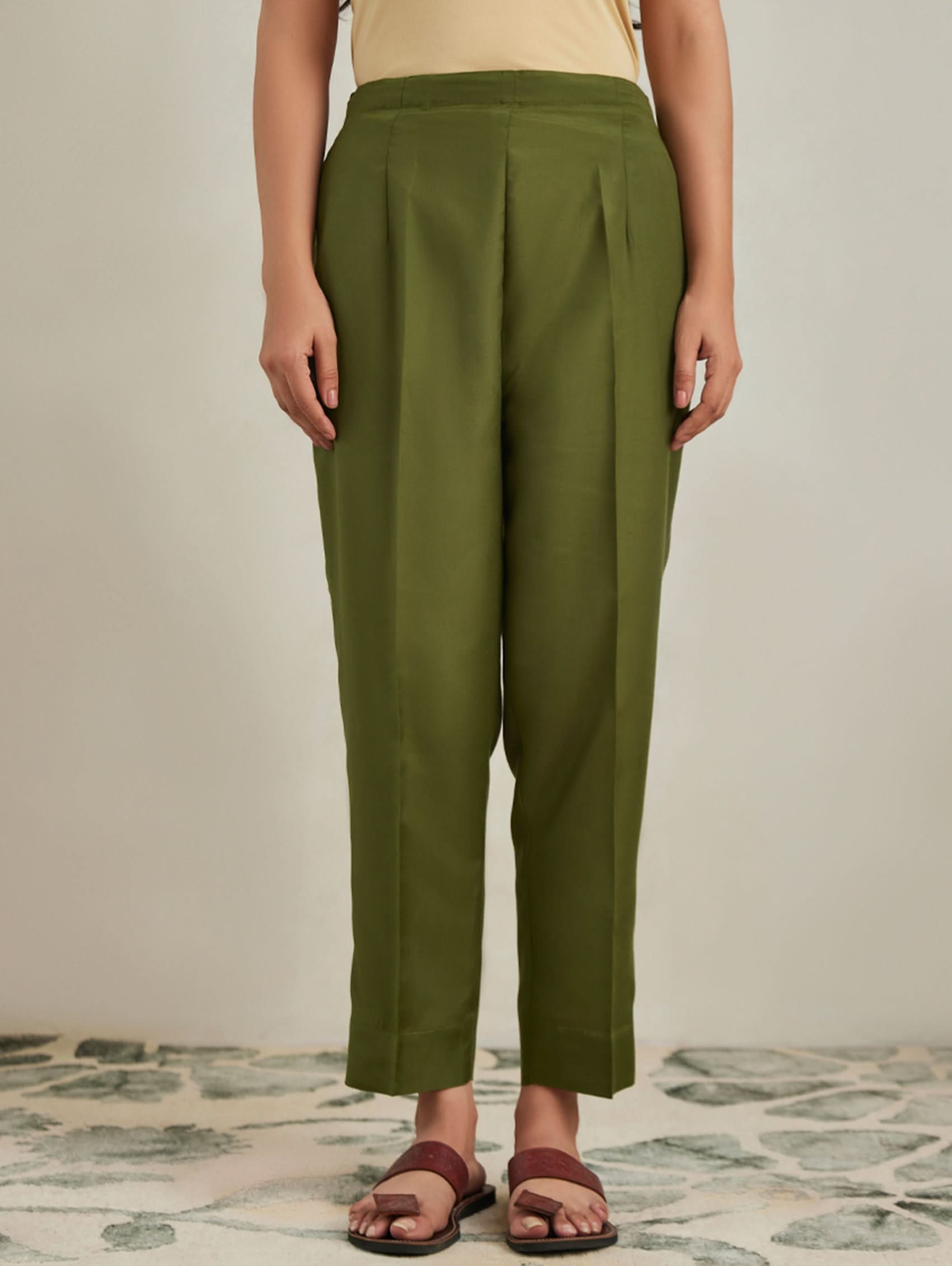 Person wearing green pants on a neutral background