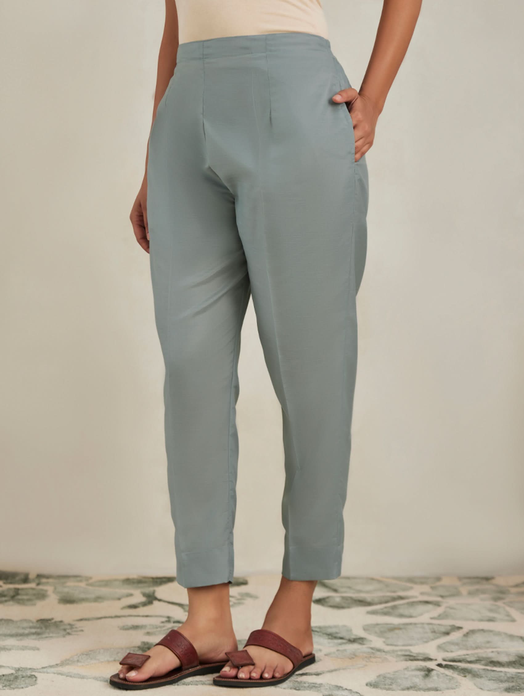 Person wearing light gray pants on a neutral background