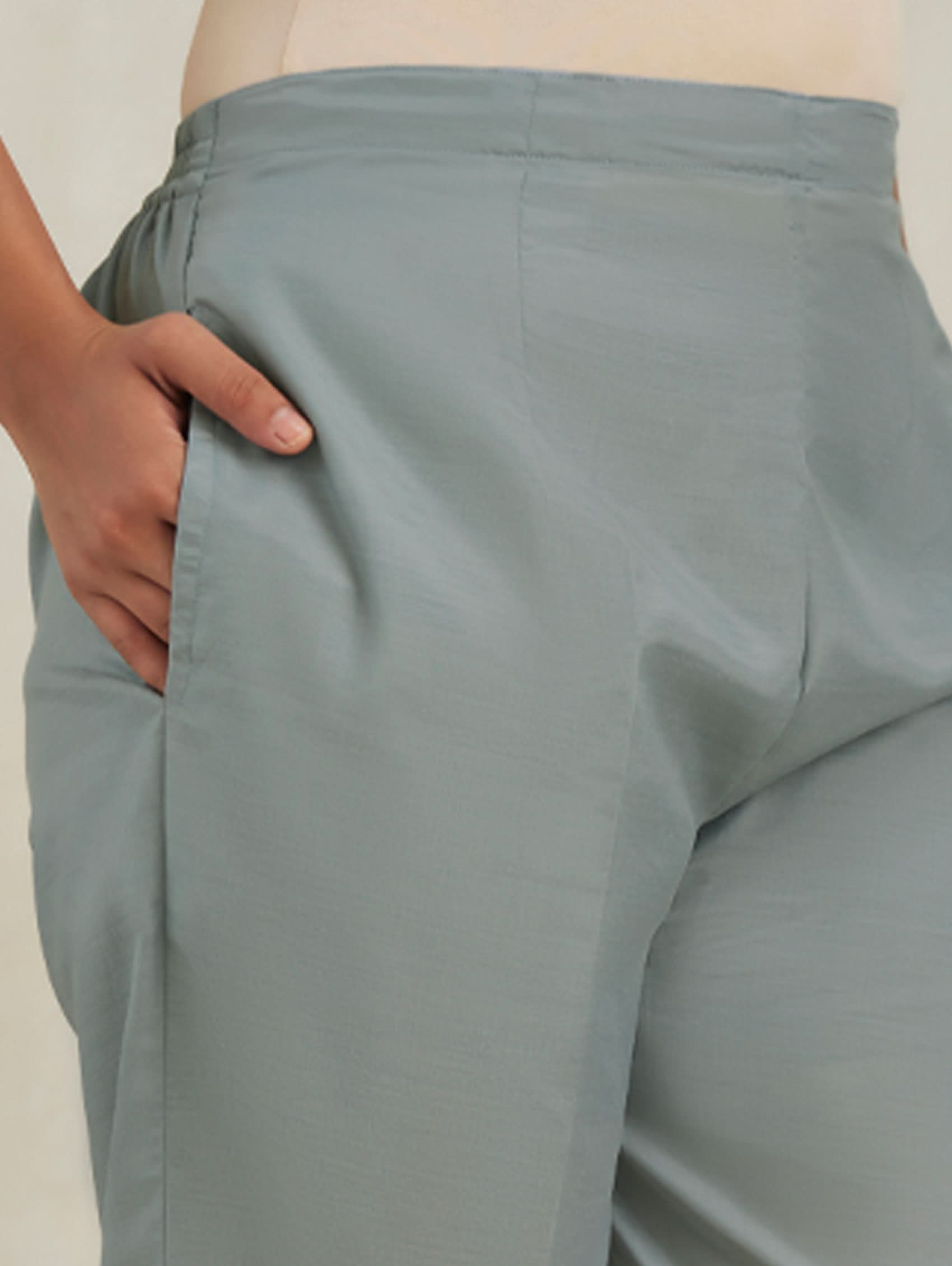Person wearing light gray pants with a neutral background