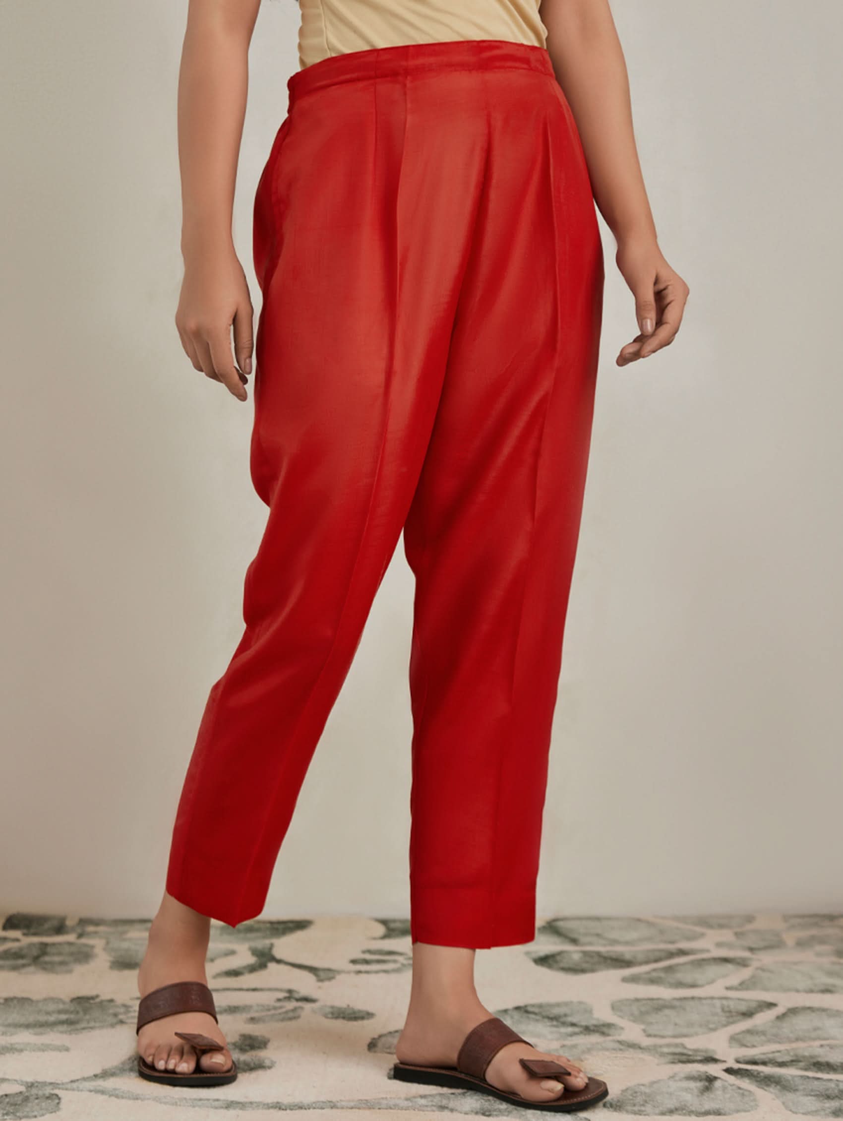 Person wearing red pants on a neutral background