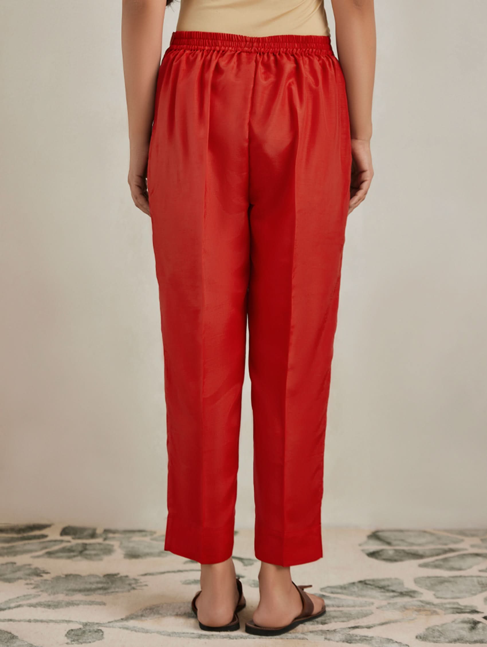 Person wearing red pants on a neutral background