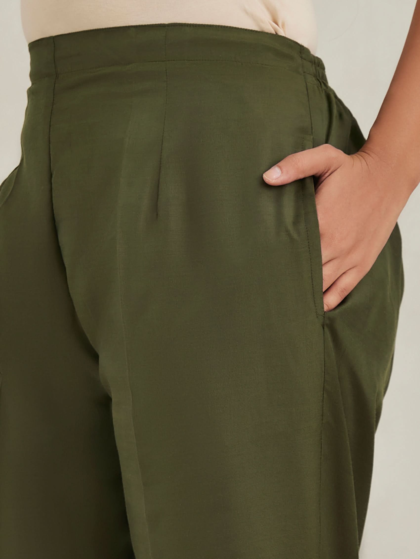 Green pants worn by a person with a neutral background