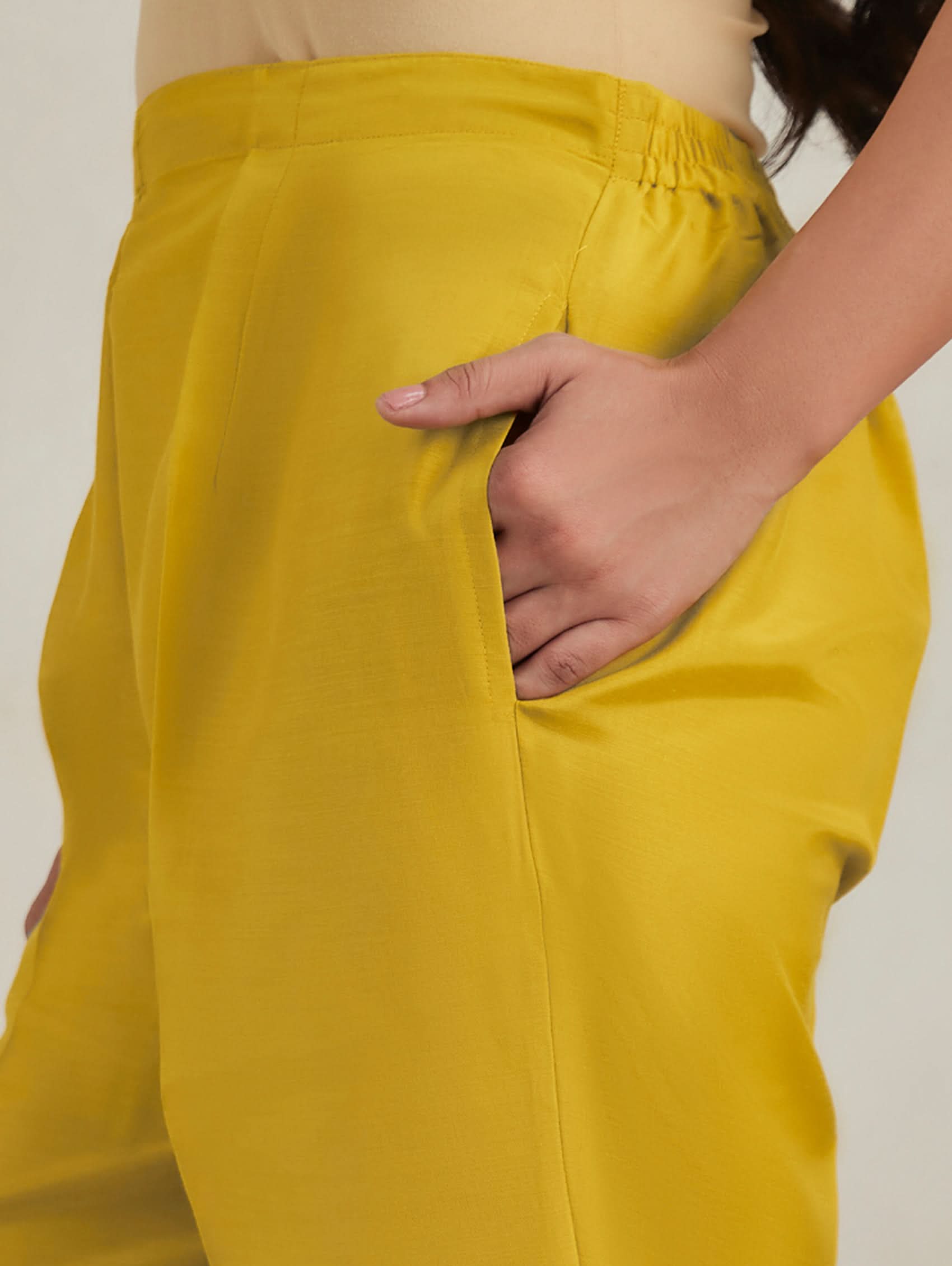 Yellow pants worn by a person with a neutral background