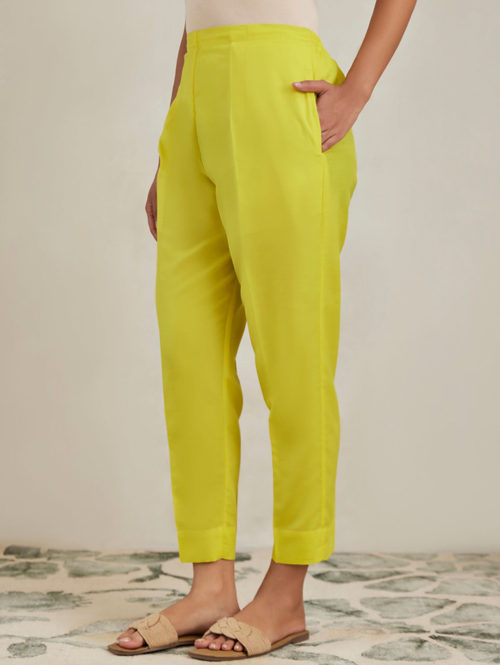 Person wearing bright yellow pants on a neutral background