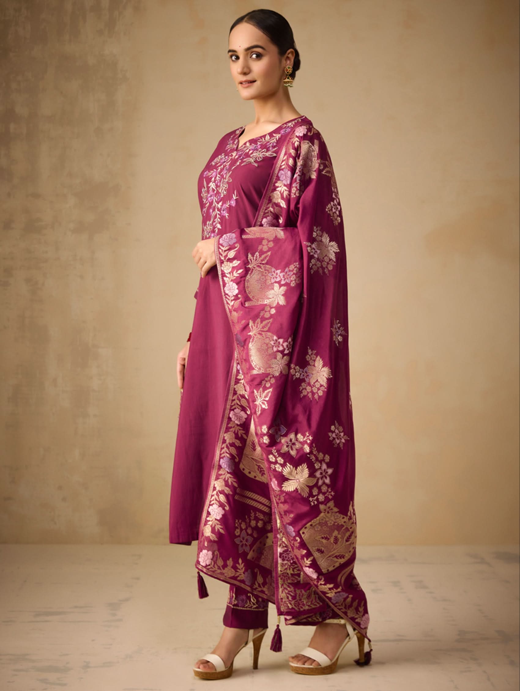 Woman wearing a purple floral outfit against a beige background