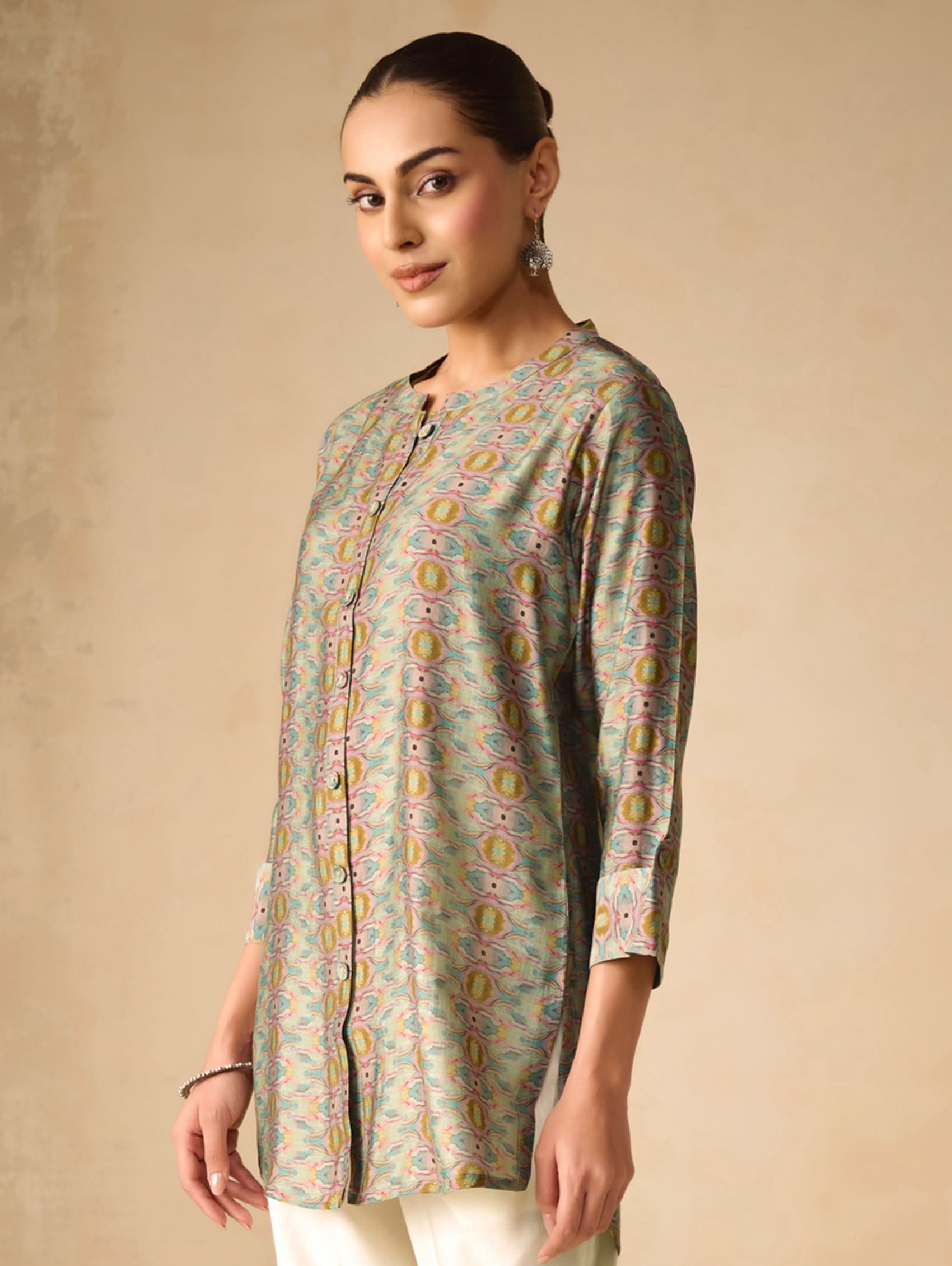 Woman wearing a patterned shirt against a beige background