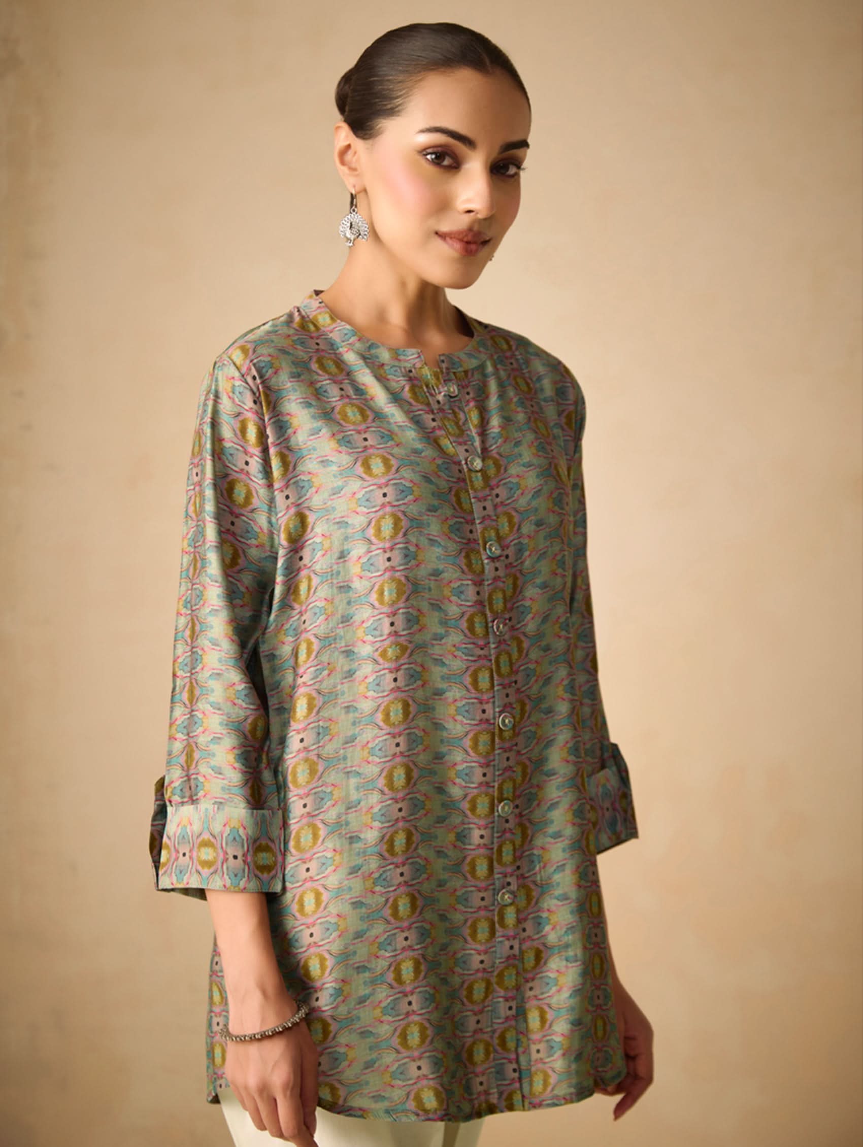 Woman wearing a patterned dress against a beige background