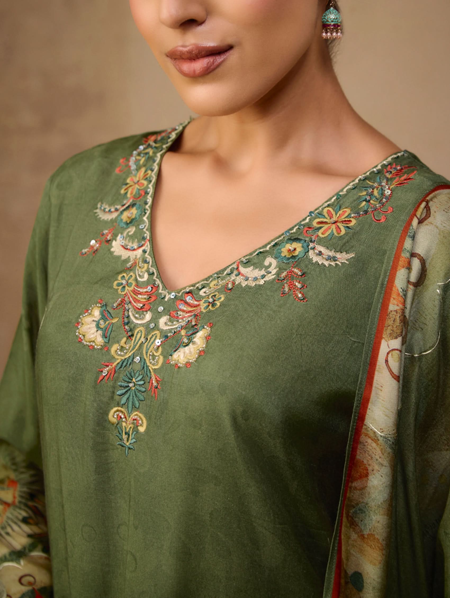 Green embroidered garment with a neutral background