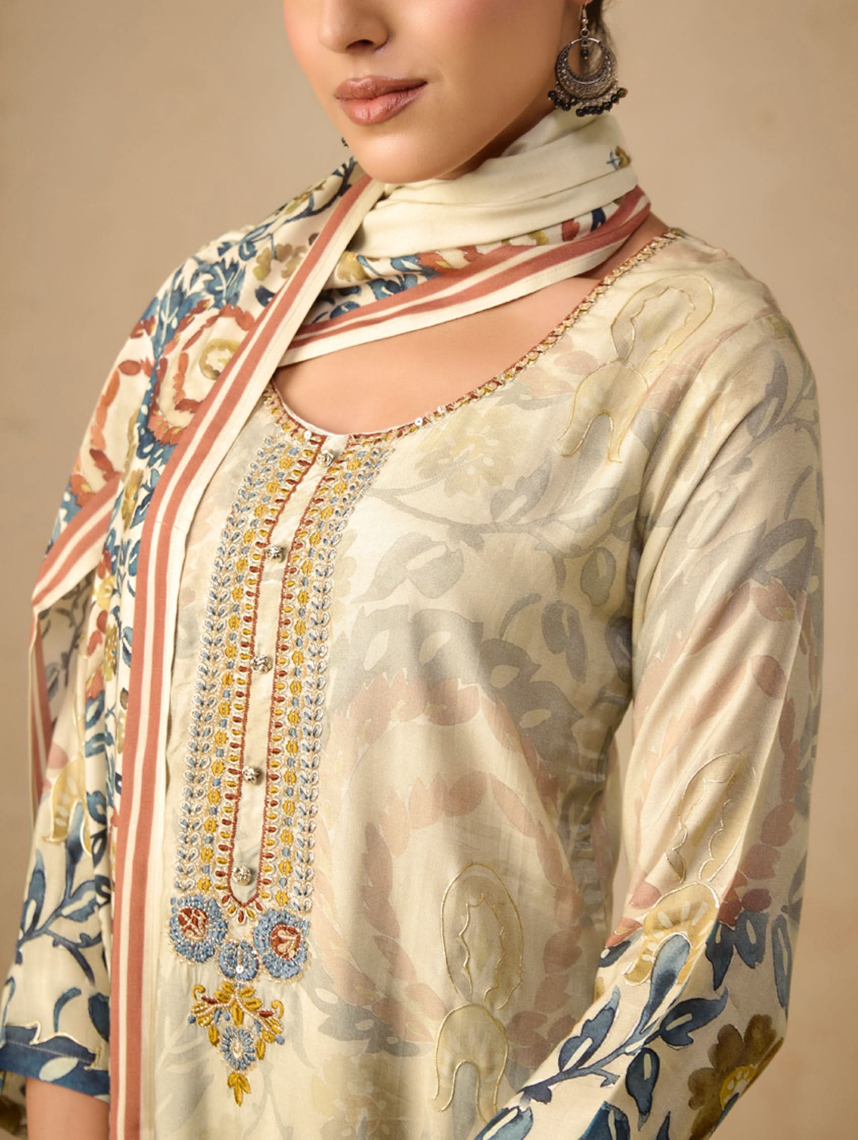 Woman wearing a floral scarf with intricate patterns on a beige background
