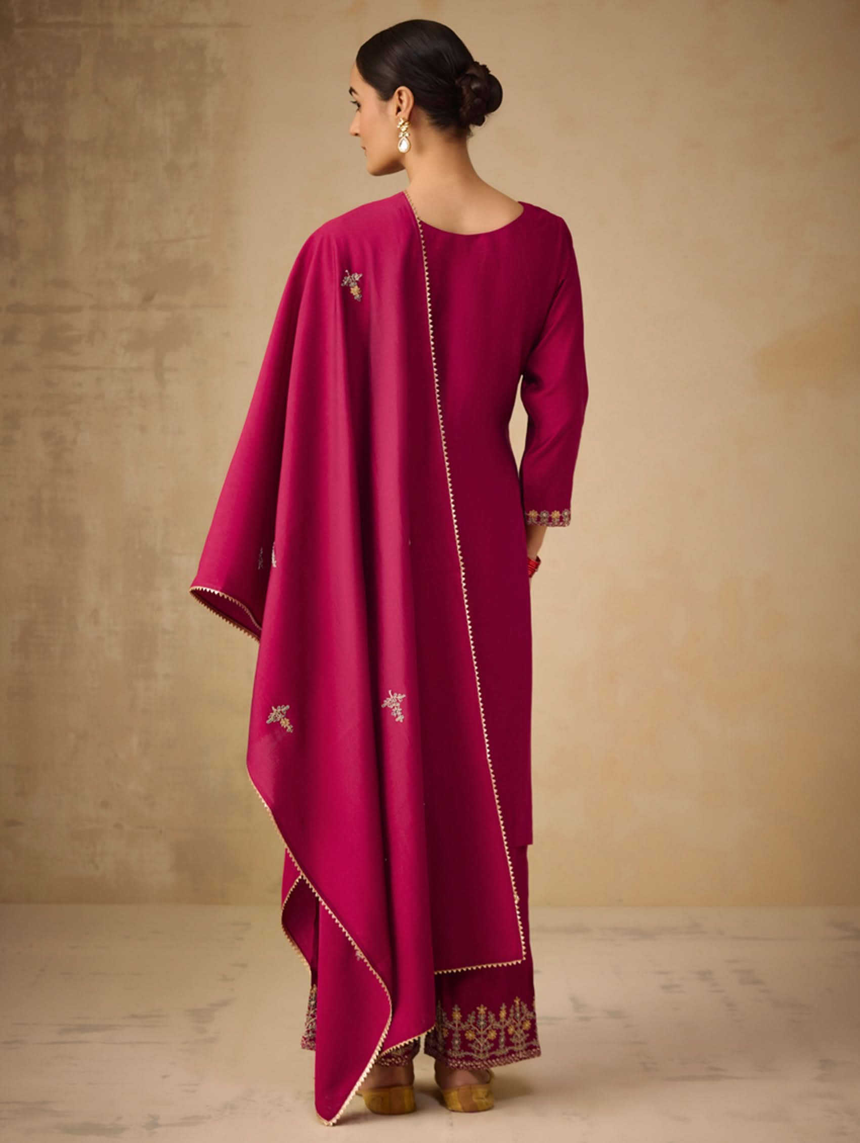 Woman wearing a magenta traditional outfit with a plain background