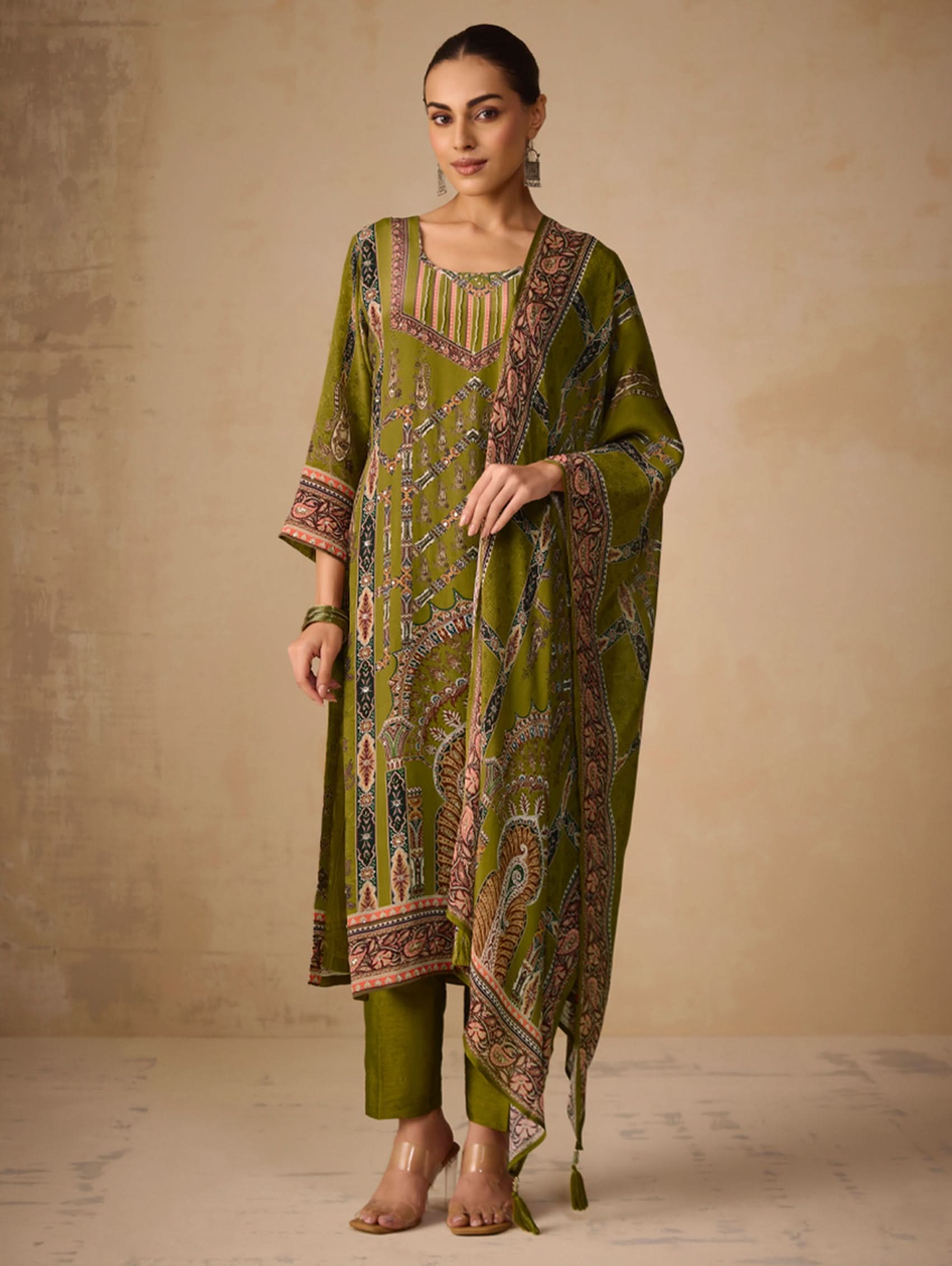 Woman wearing a green patterned outfit against a beige background