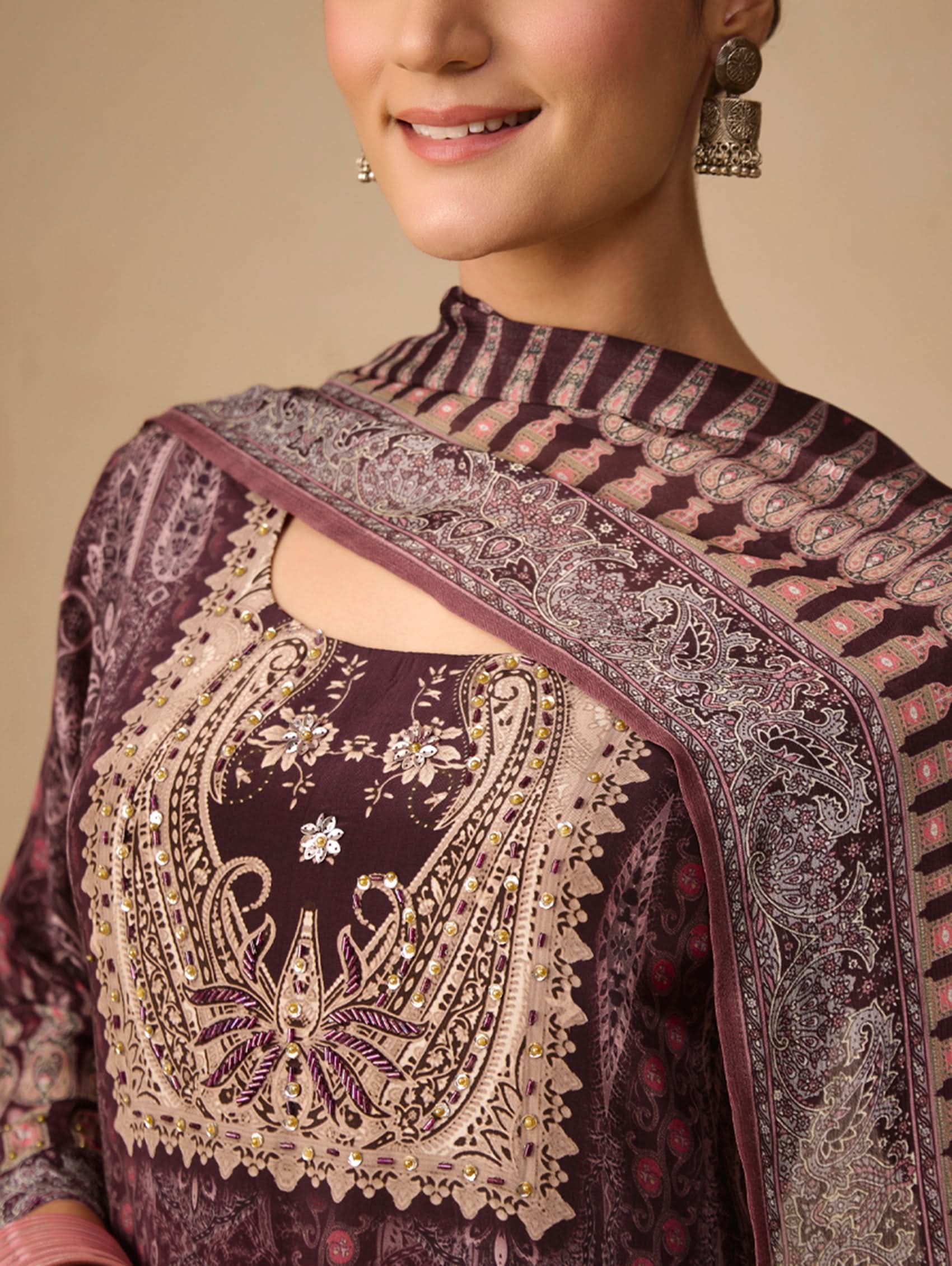 Woman wearing a traditional embroidered outfit with a beige background