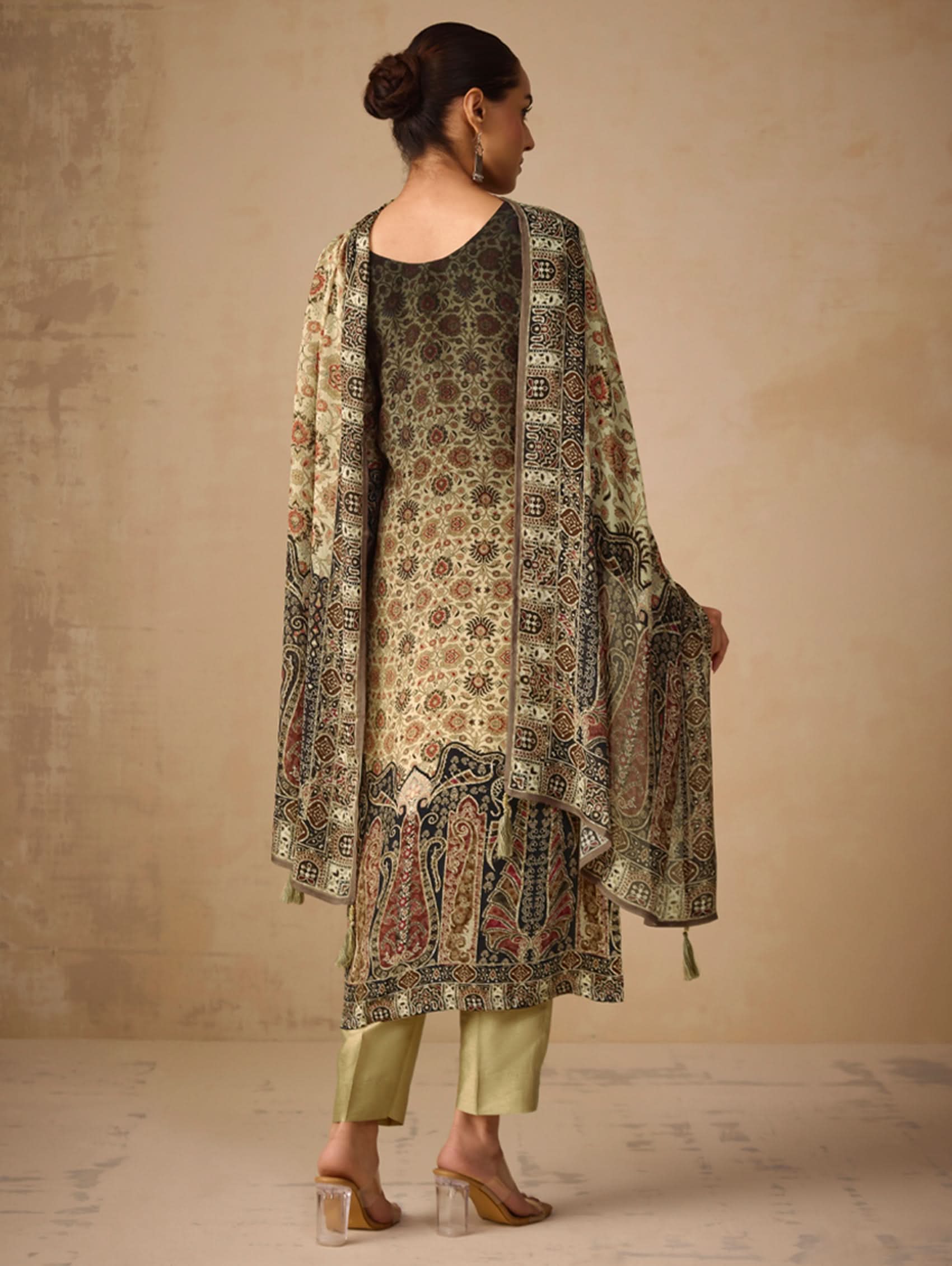 Woman wearing a patterned outfit with a beige background