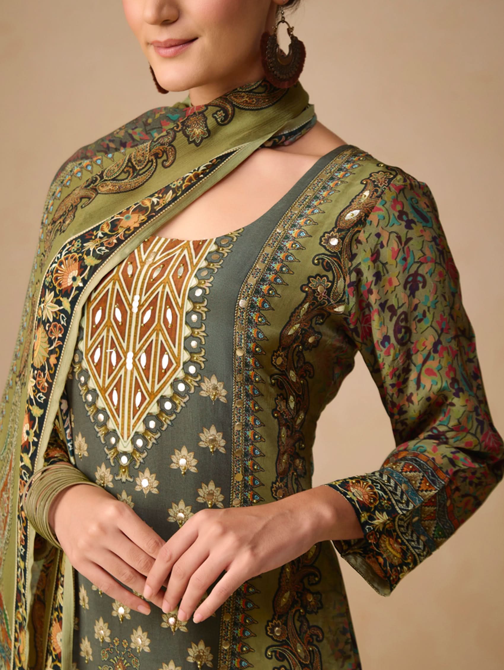 Traditional embroidered outfit with intricate patterns on a beige background