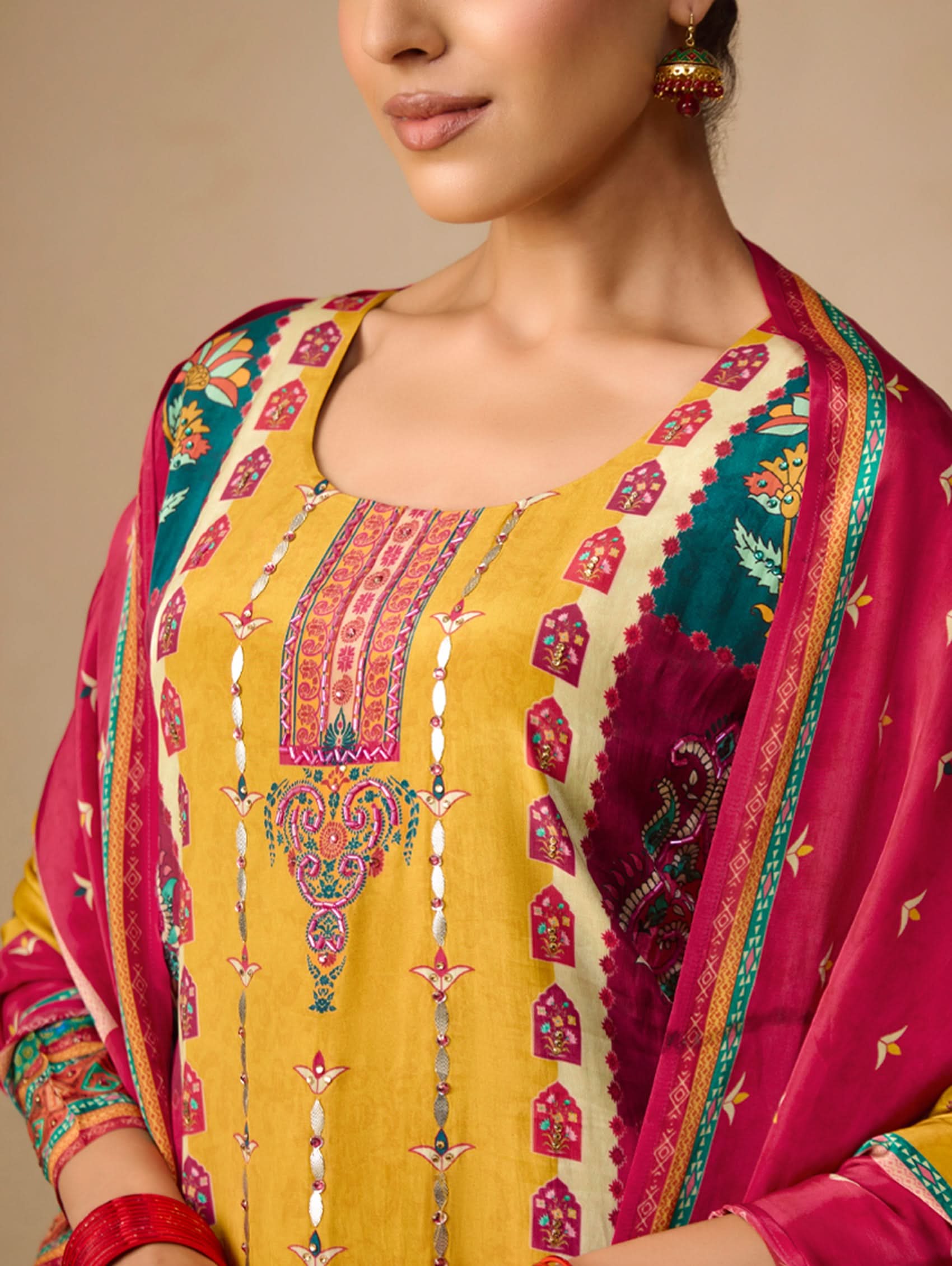 Traditional embroidered yellow and pink outfit with intricate patterns