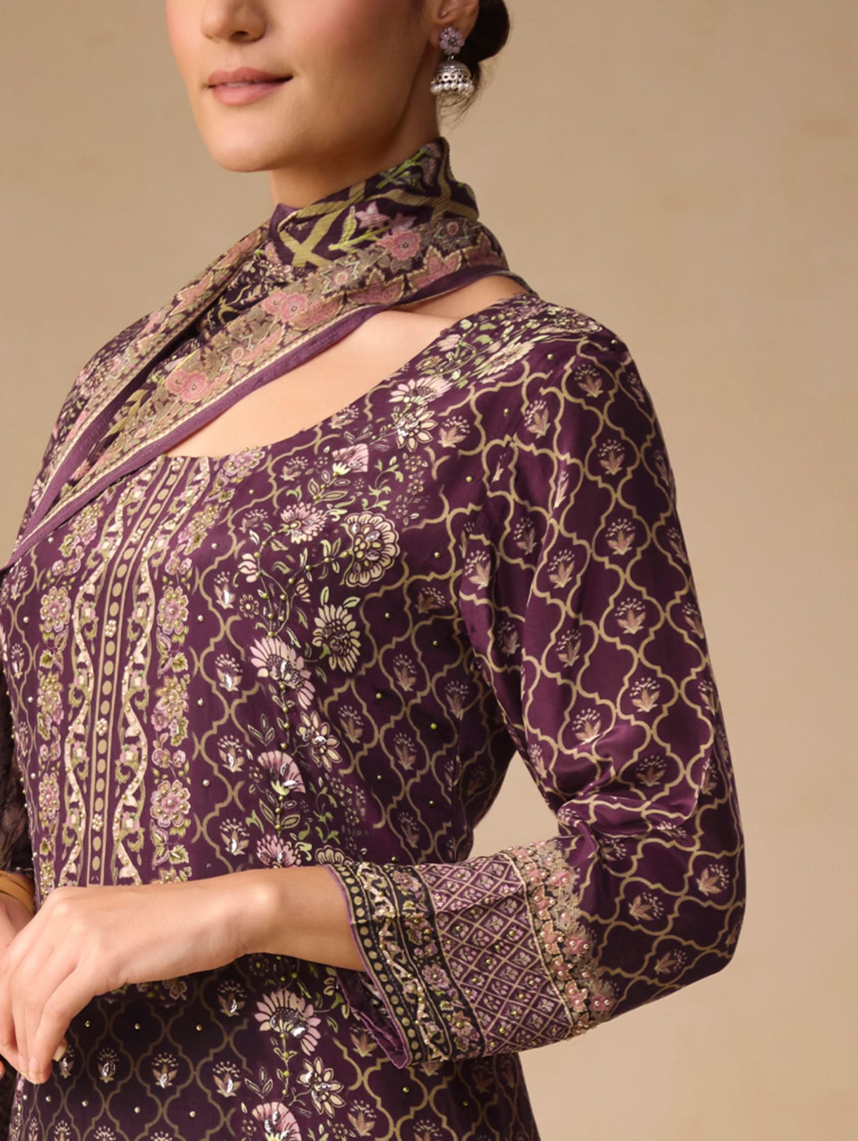 Purple patterned blouse with intricate designs on a beige background