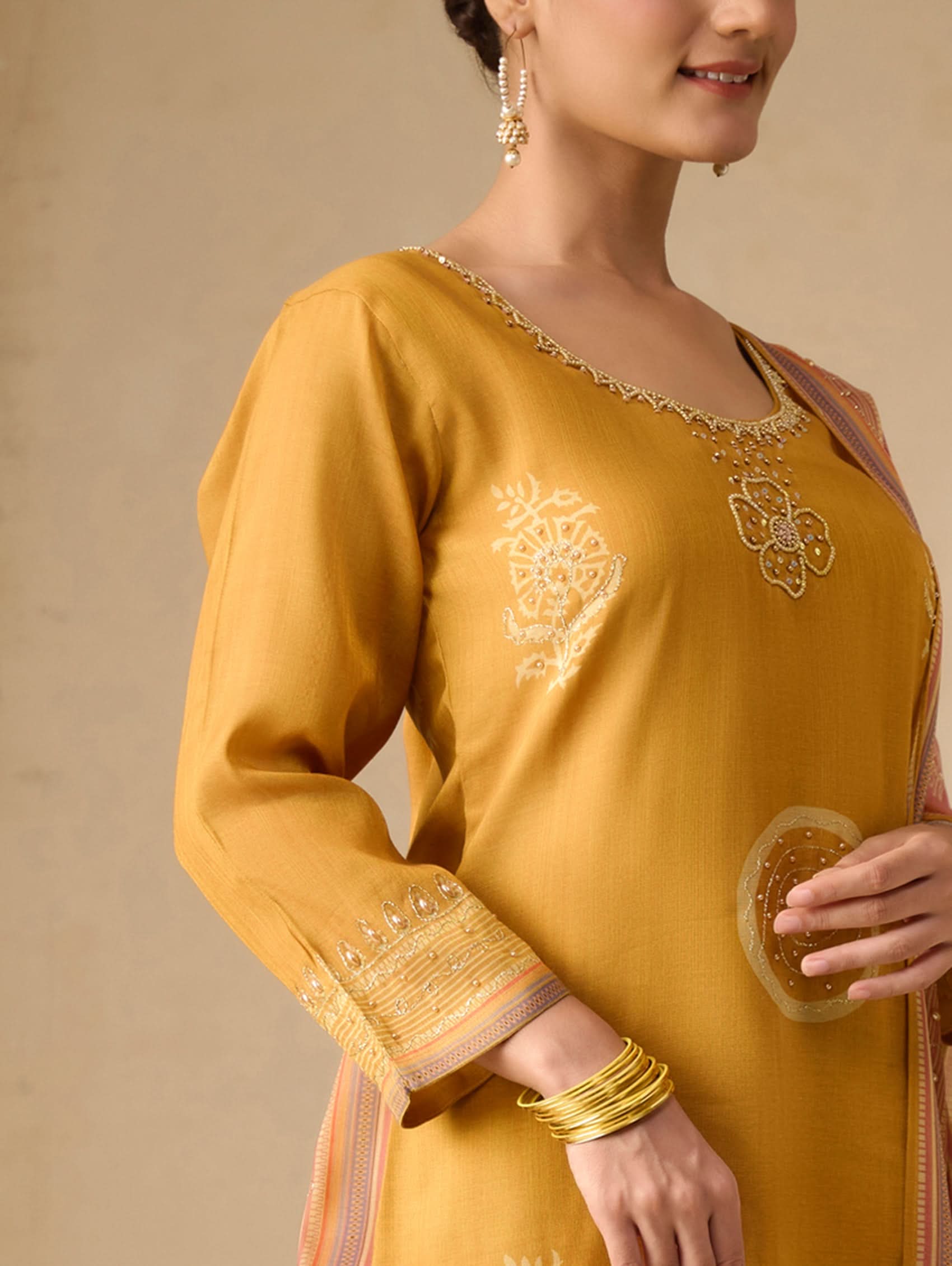 Yellow embroidered traditional outfit with a plain background