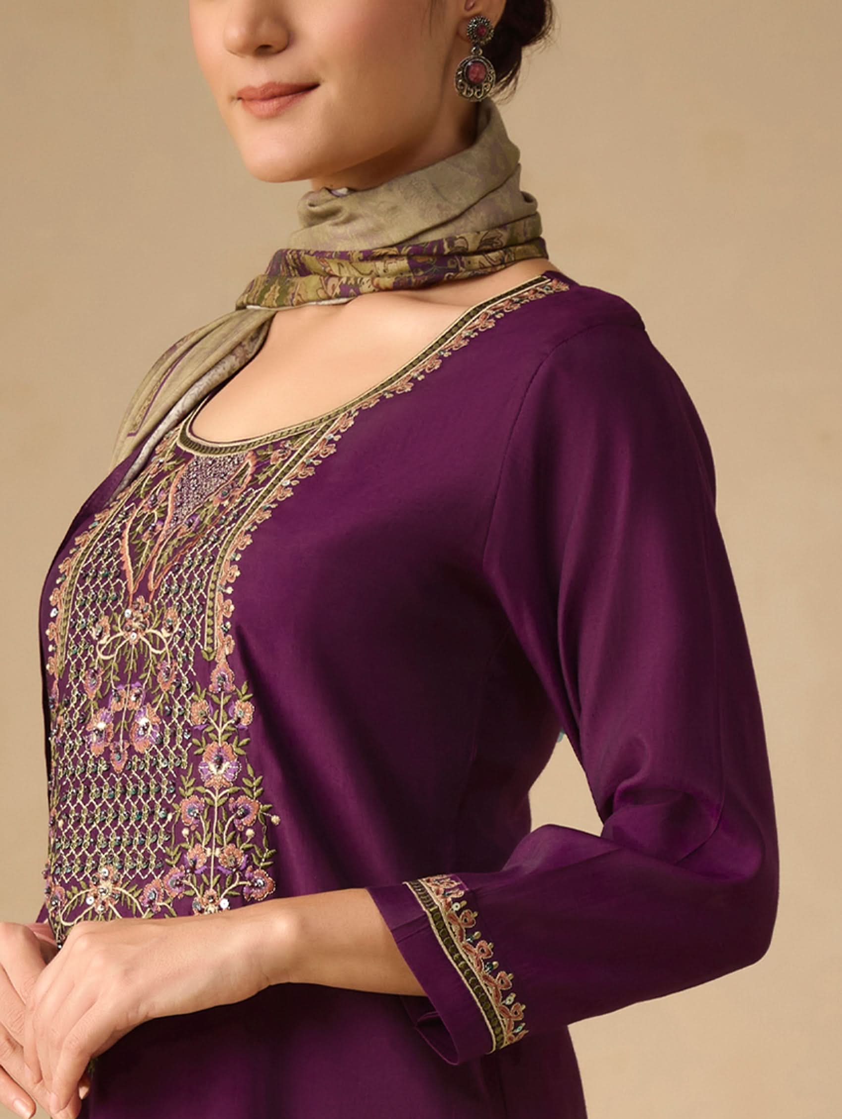 Purple embroidered top worn by a person on a beige background