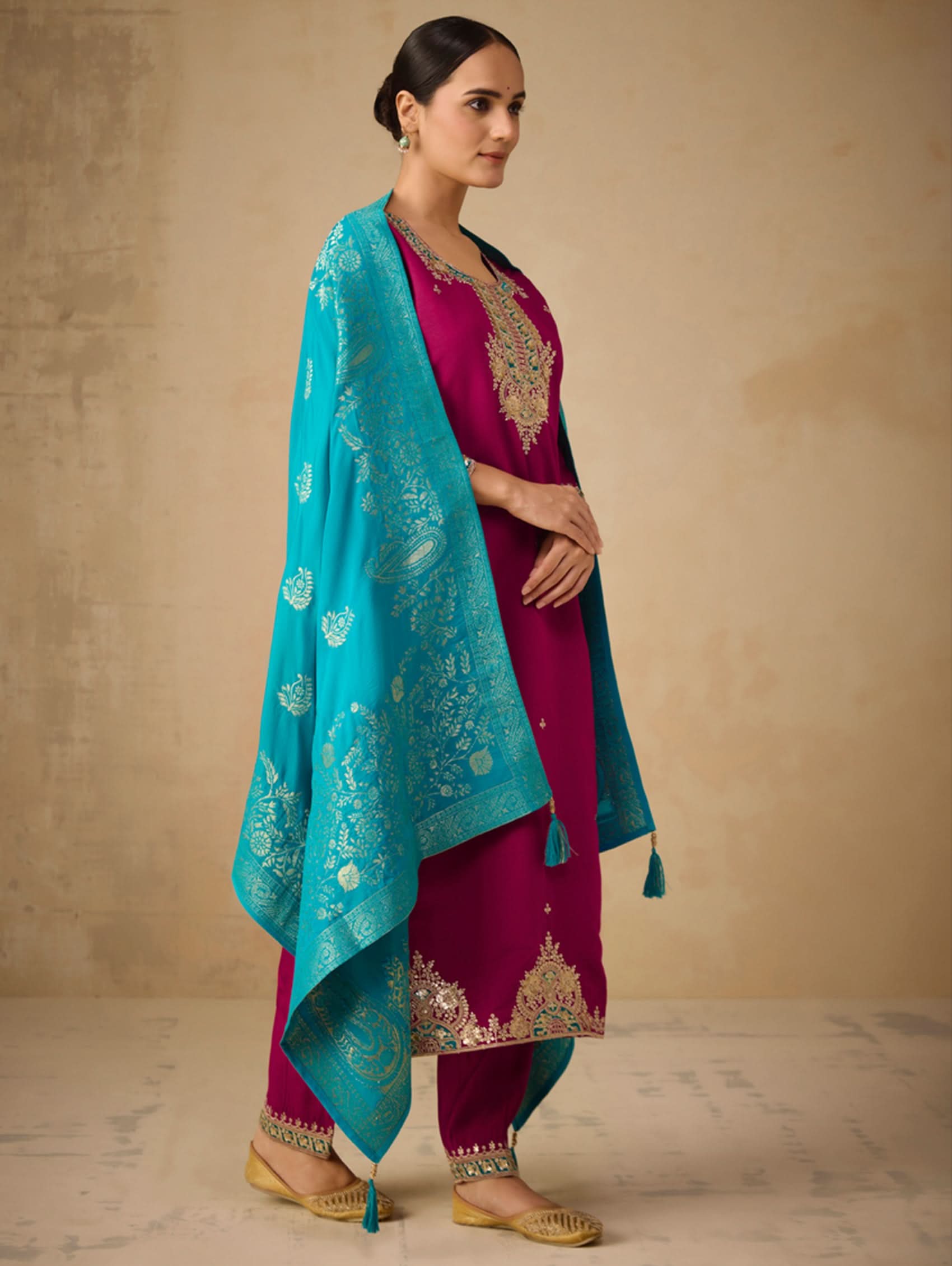 Side view of embroidered berry suit set with teal dupatta and gold accents