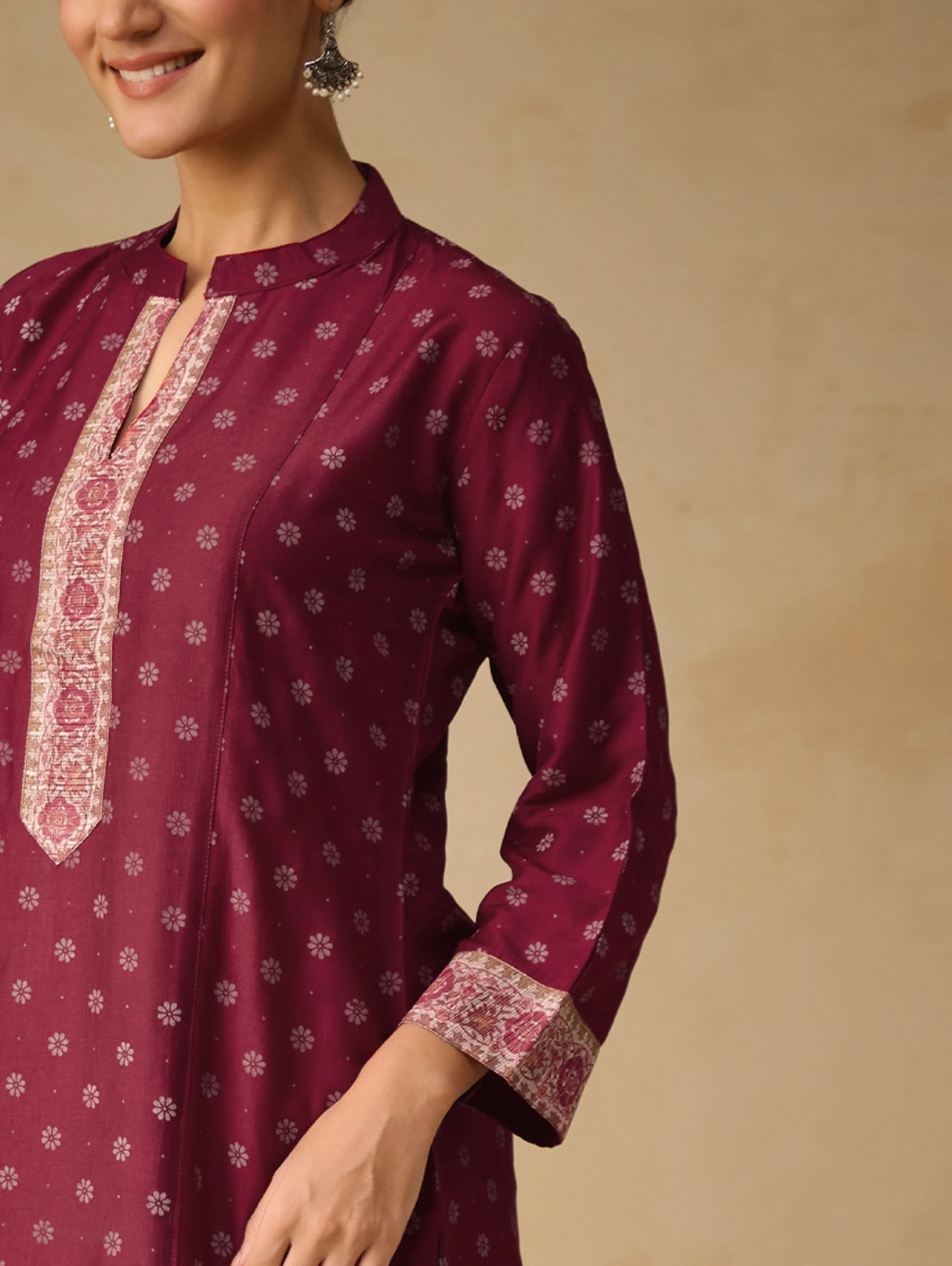 Maroon traditional kurta with white patterns on a beige background