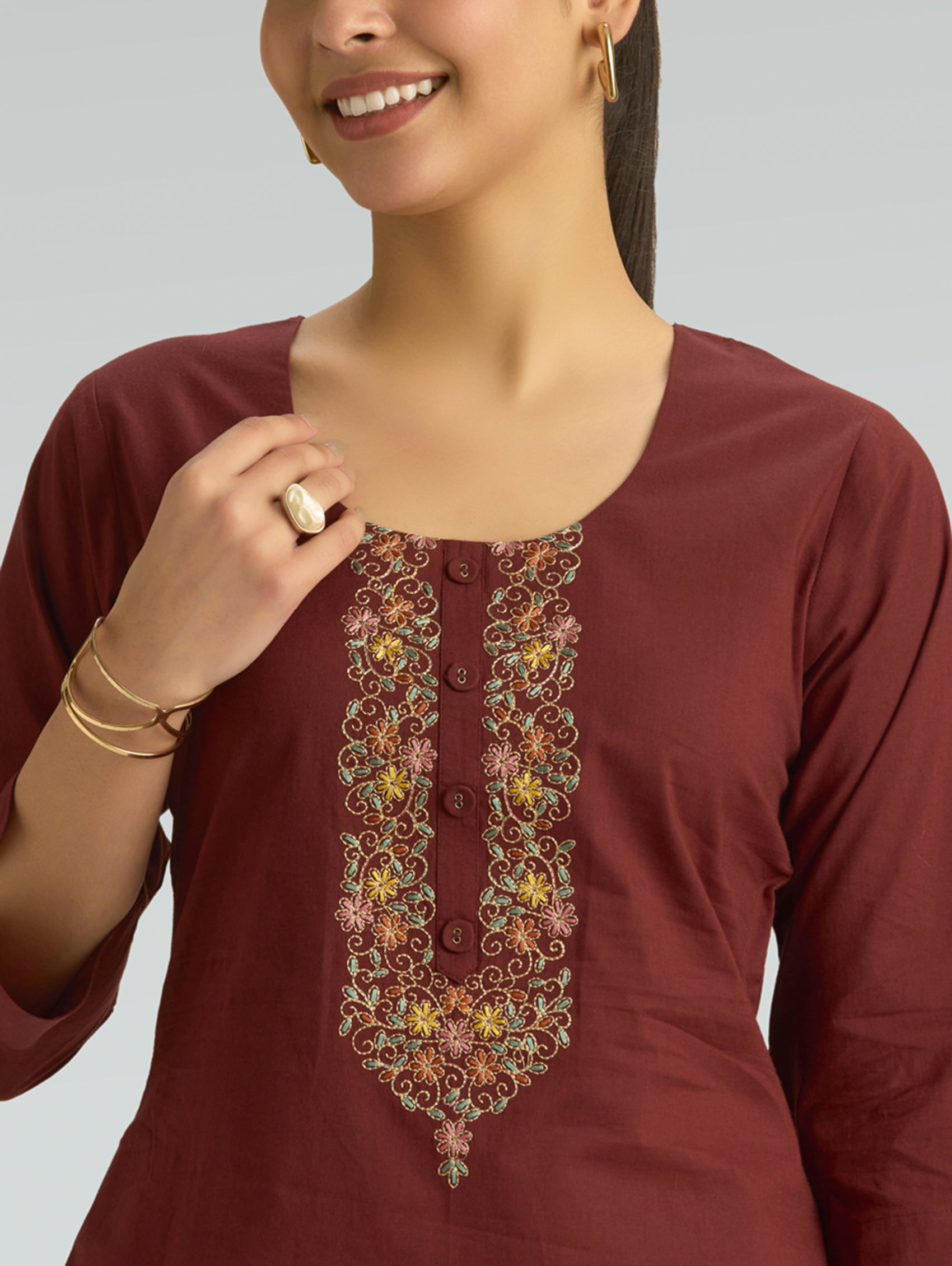 Maroon kurta with floral embroidery on a plain background