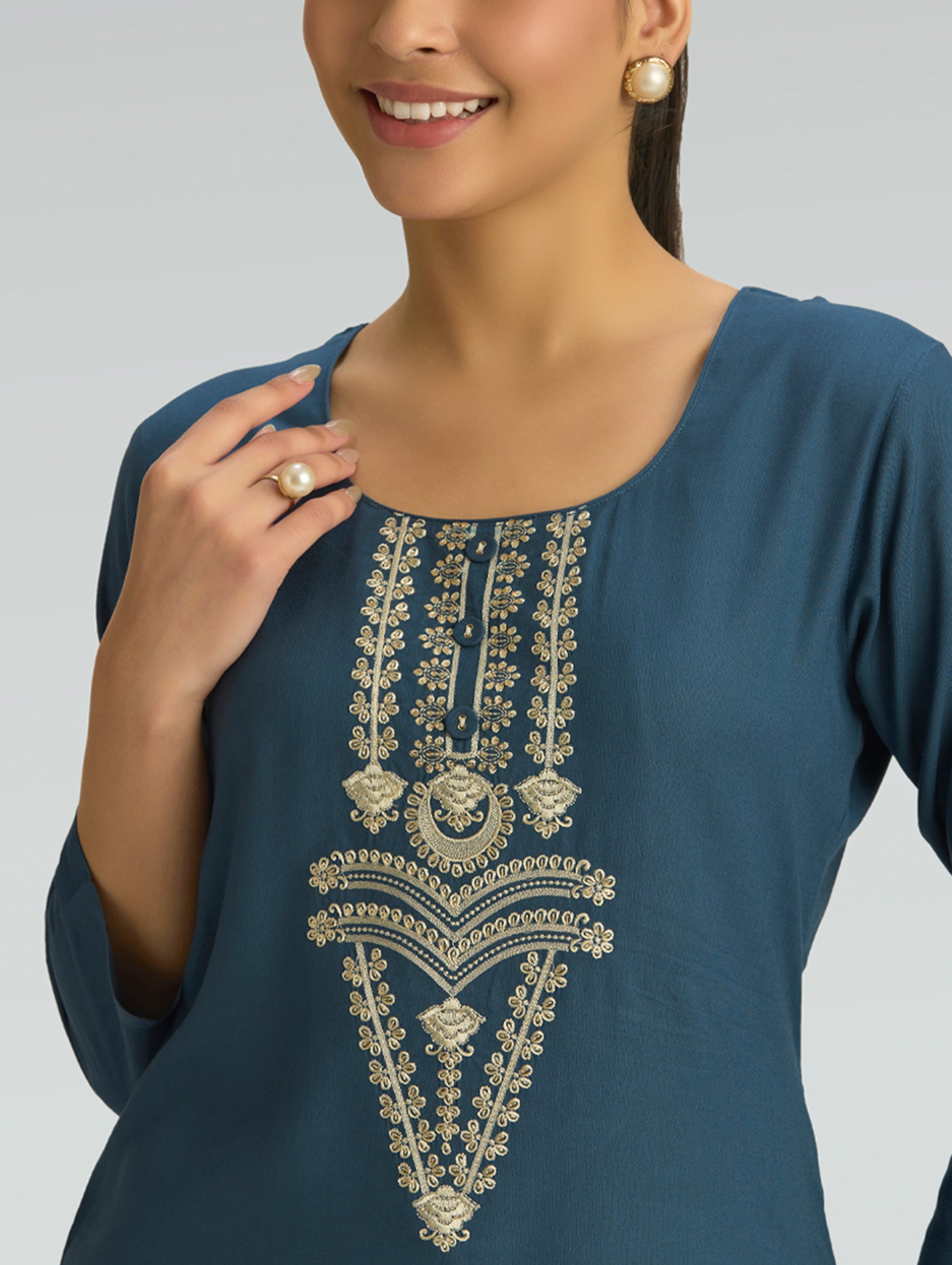 Navy blue top with gold embroidery on a plain background