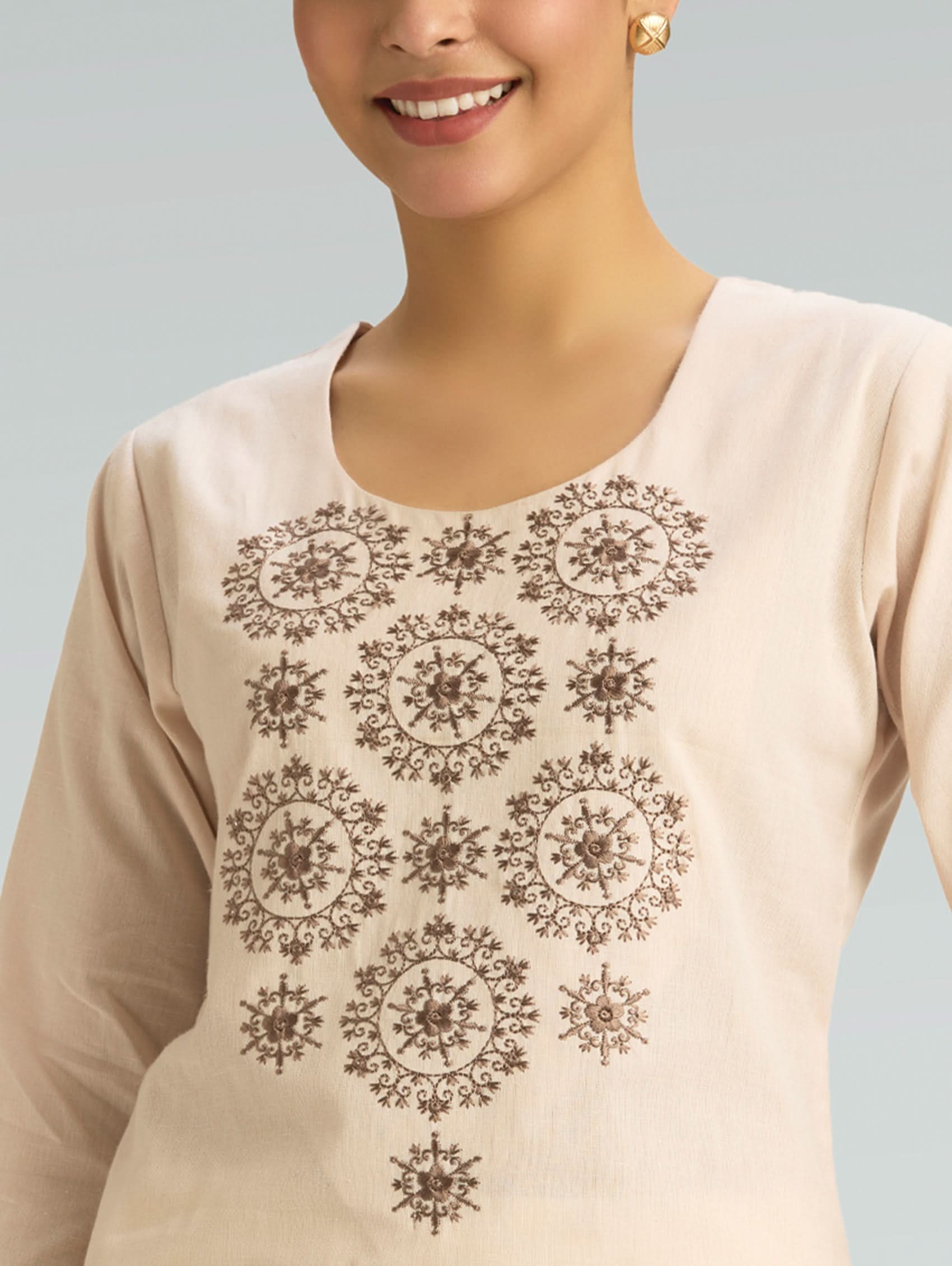 Beige top with intricate black patterns on a plain background