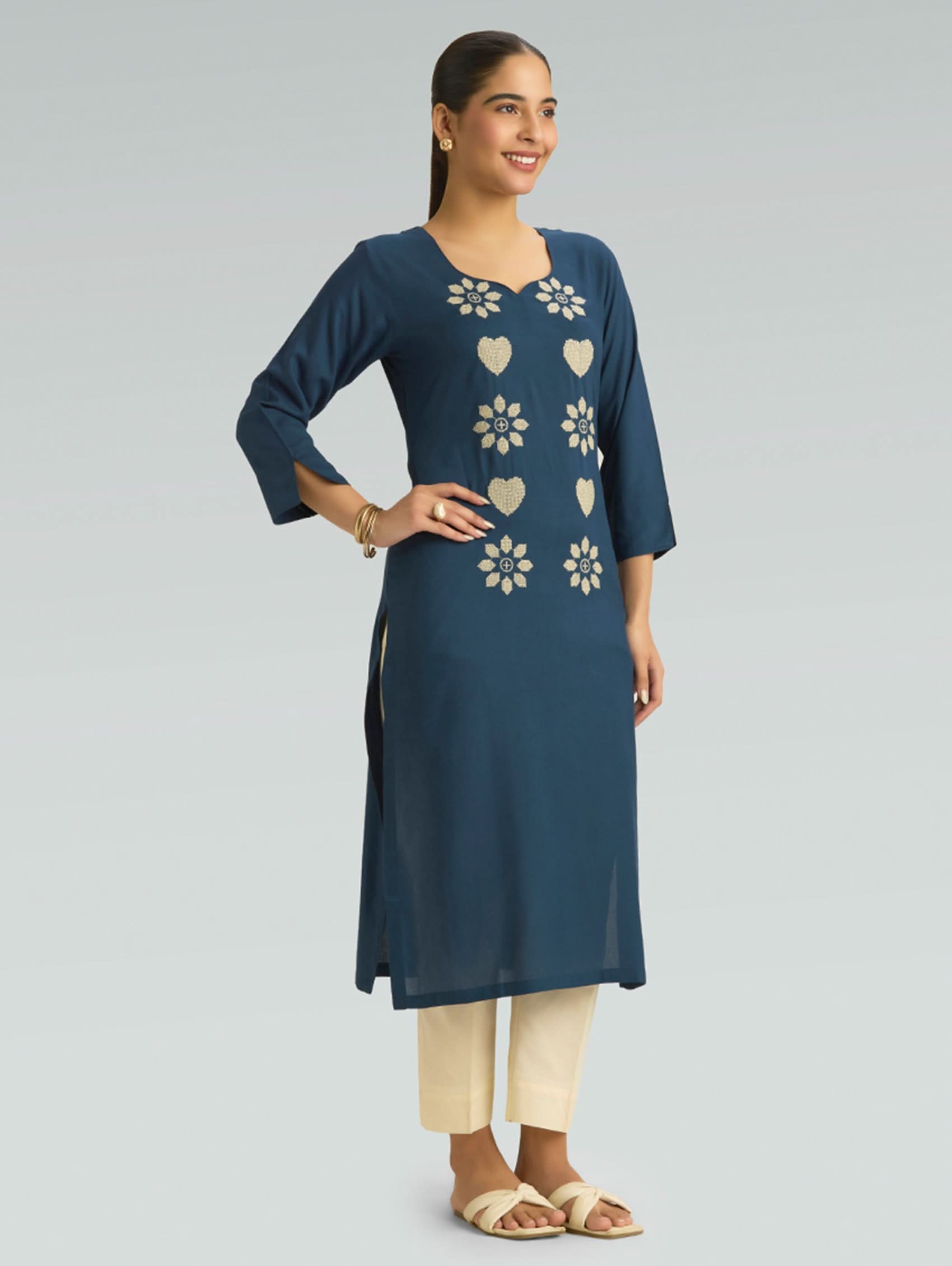 Woman wearing a blue kurta with floral patterns on a light gray background