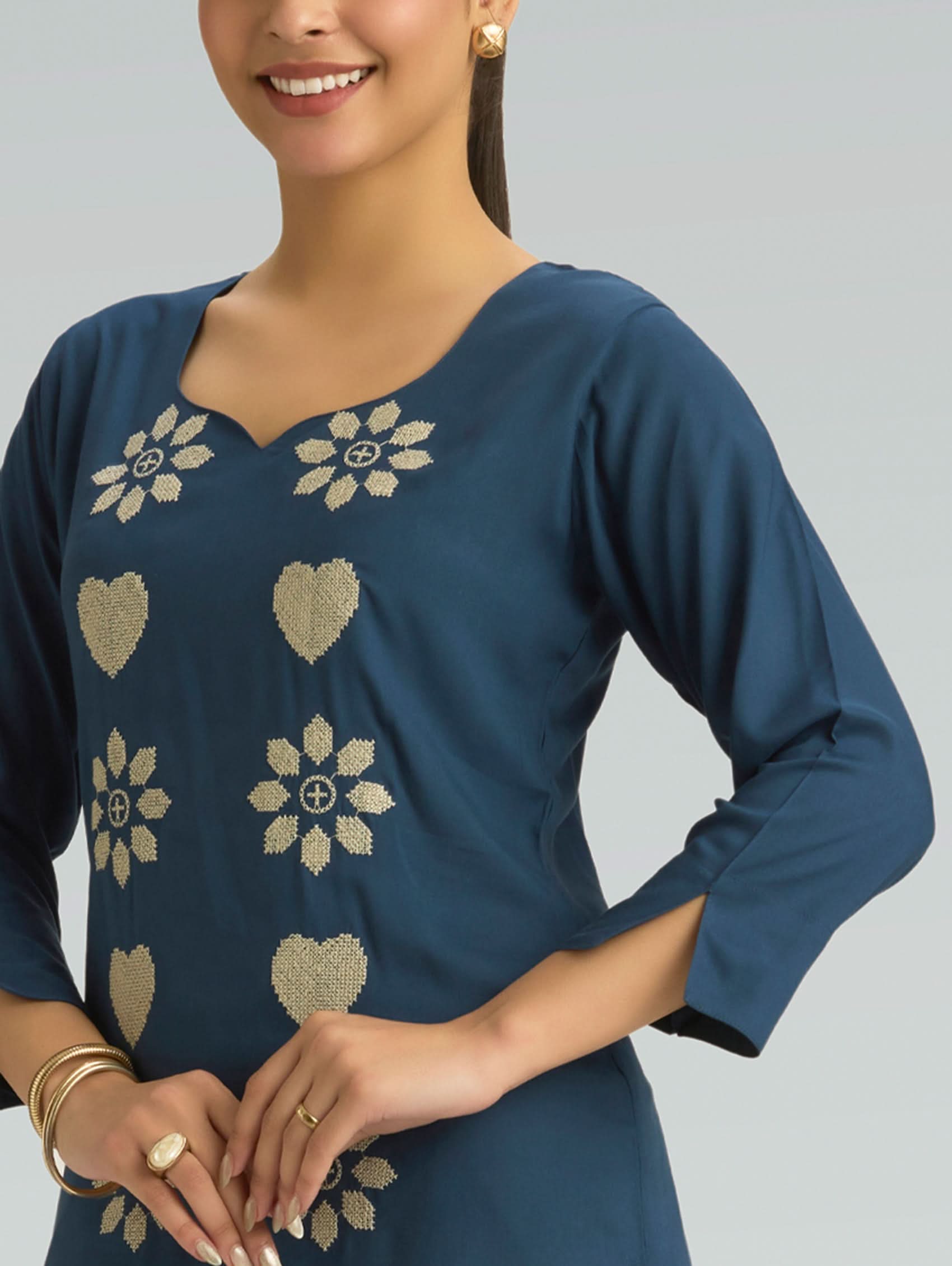 Woman wearing a blue dress with floral patterns on a gray background